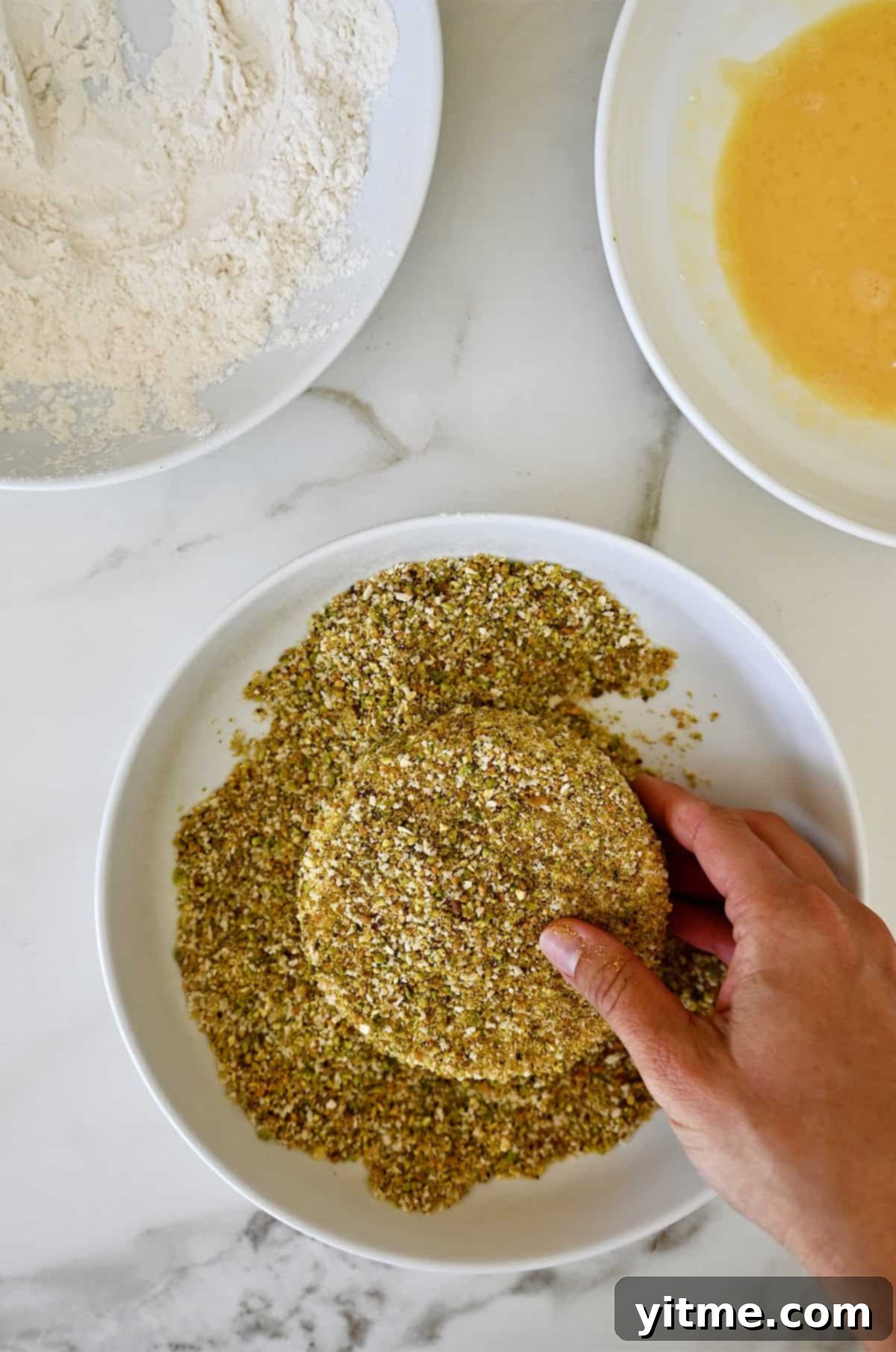 Brie cheese dredged in flour, egg wash, and ground pistachios.