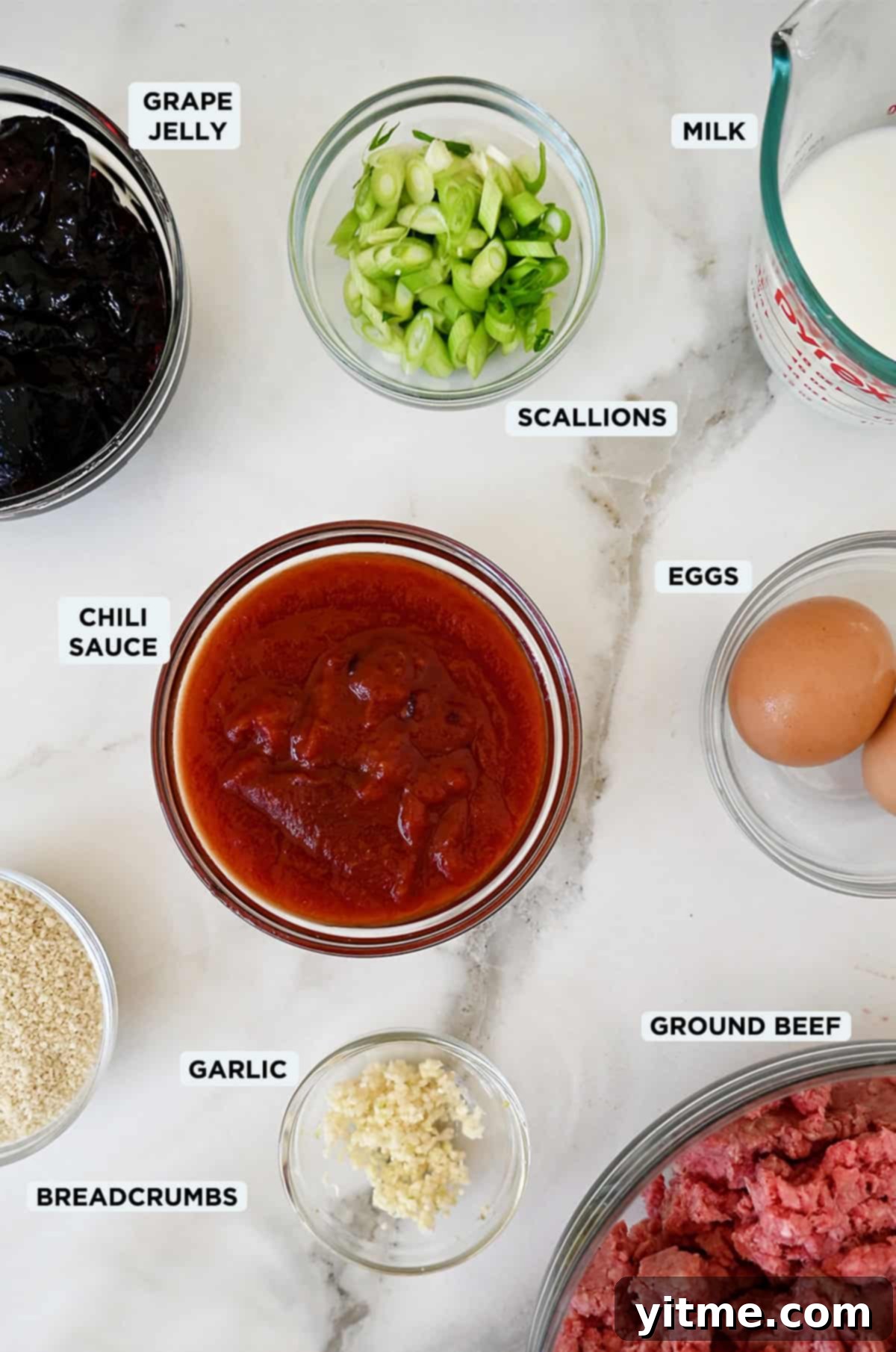 Cocktail meatball ingredients in various sizes of glass bowls.