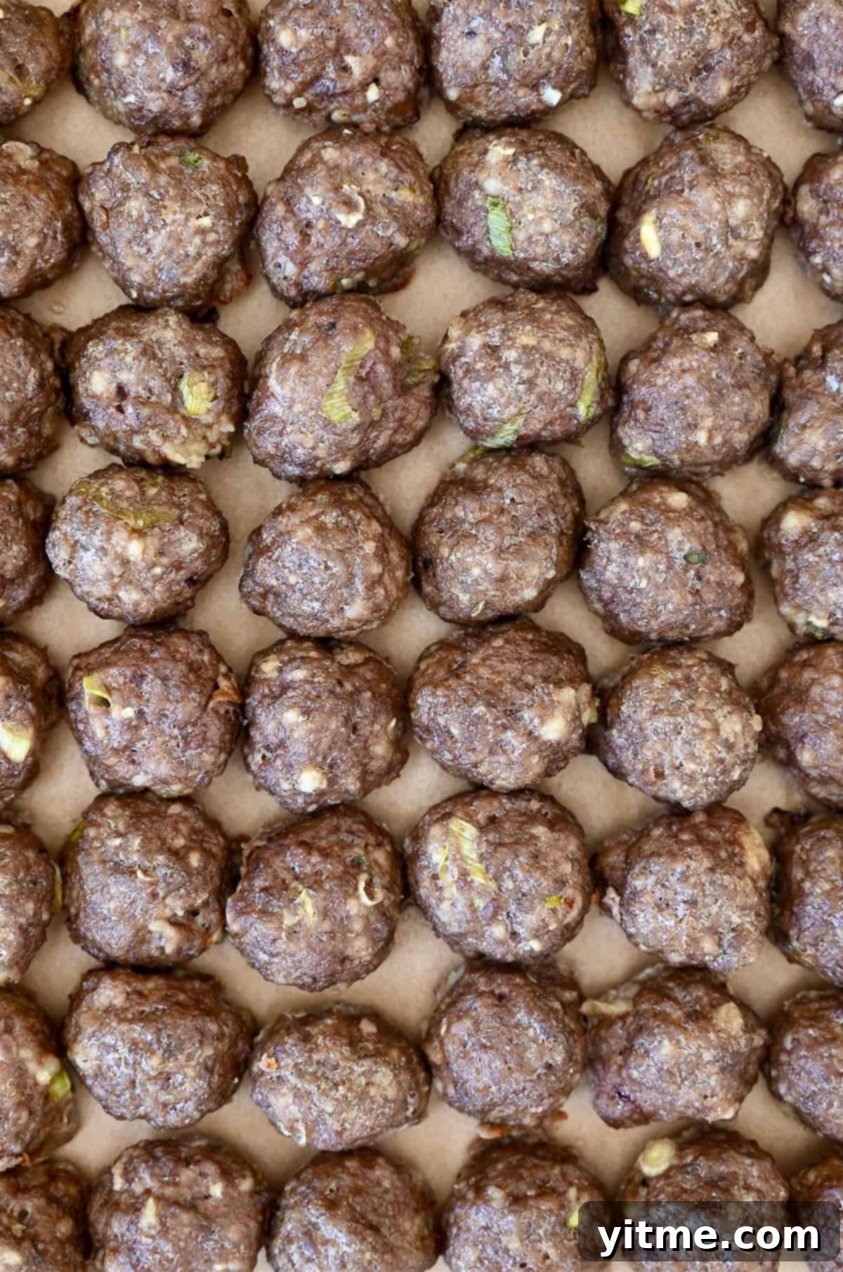 Baked cocktail meatballs lined up in perfect rows.