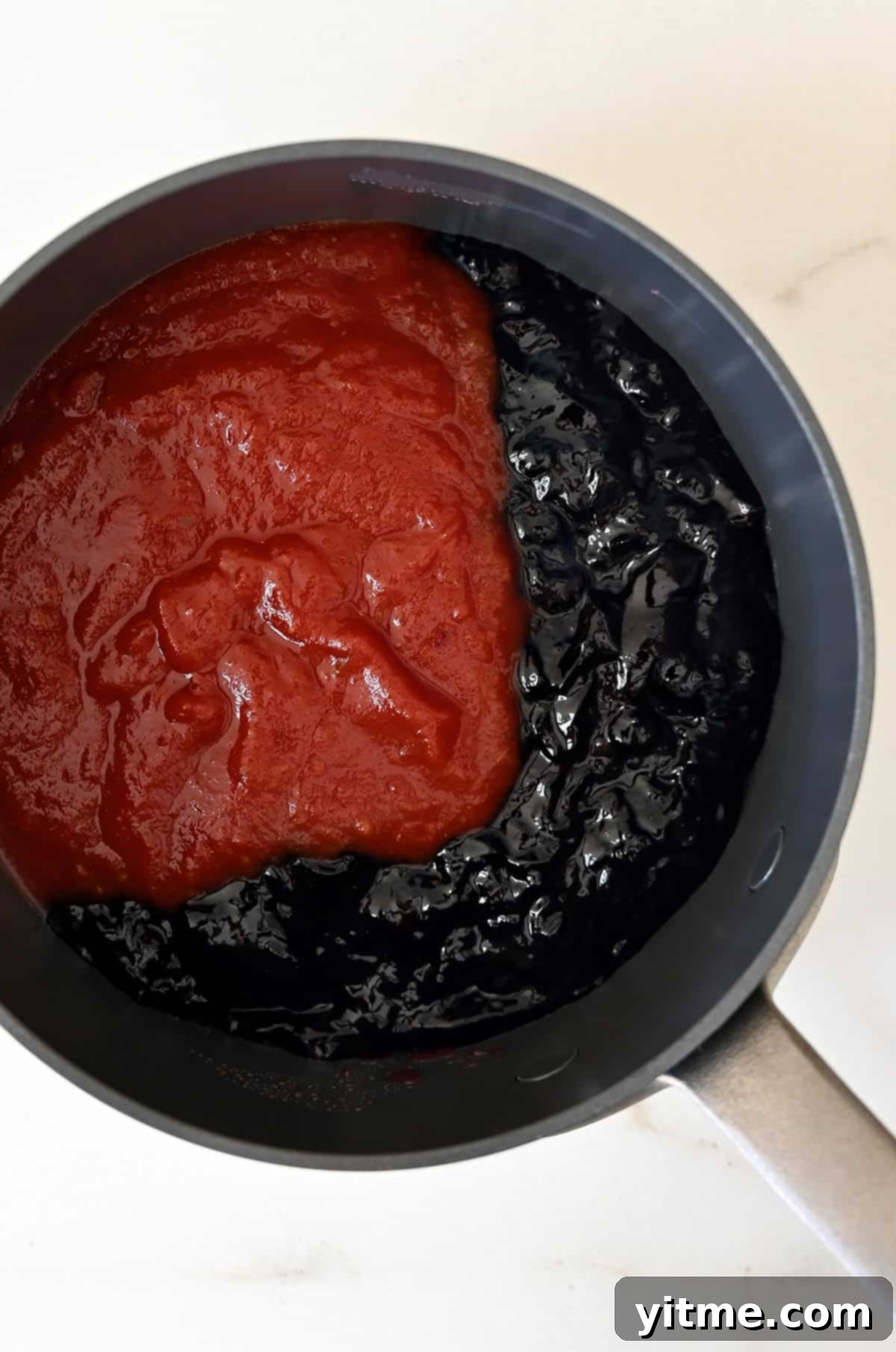 Grape jelly and chili sauce in a saucepan.