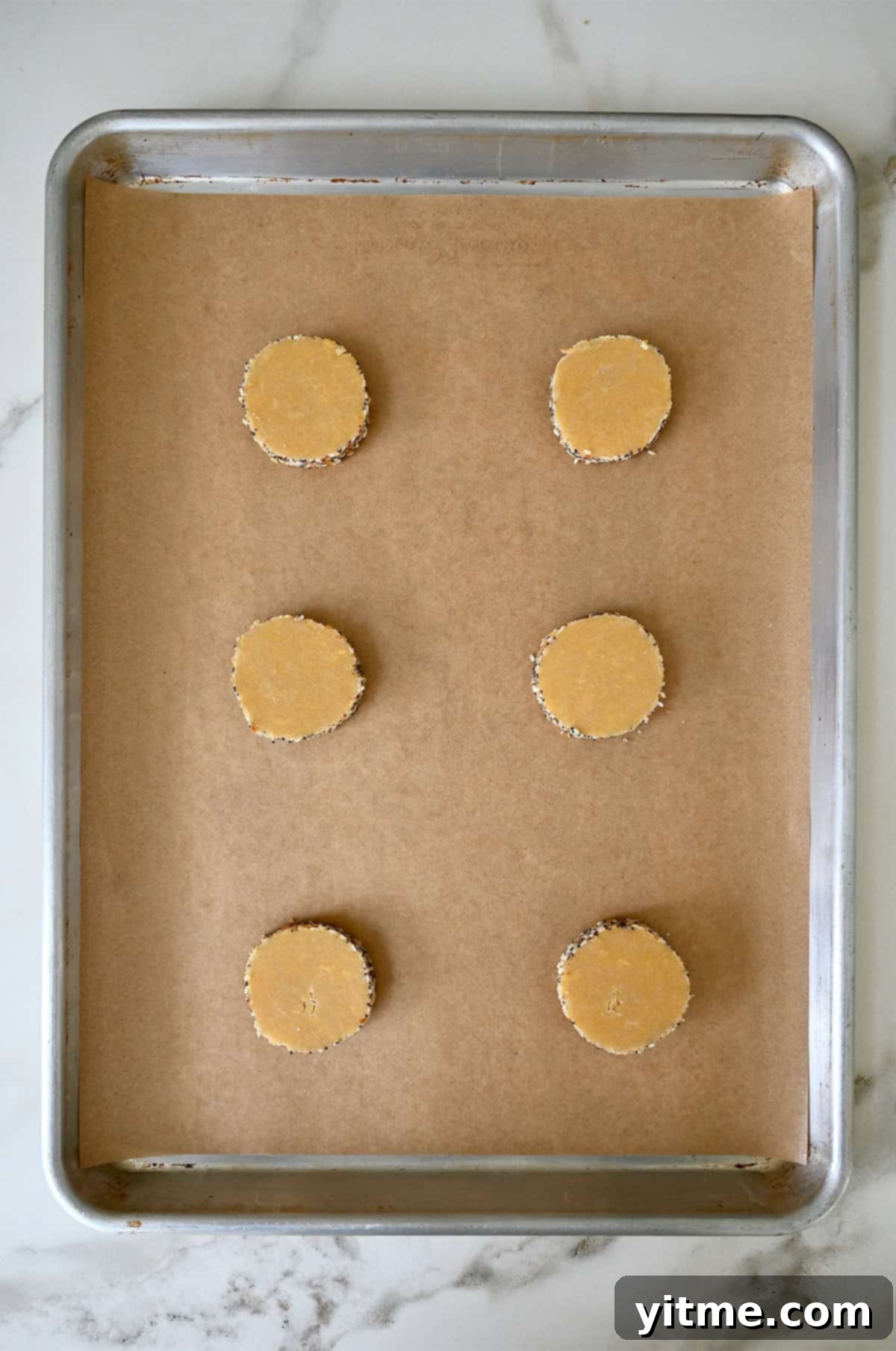 Unbaked cheddar cookies on a baking sheet.