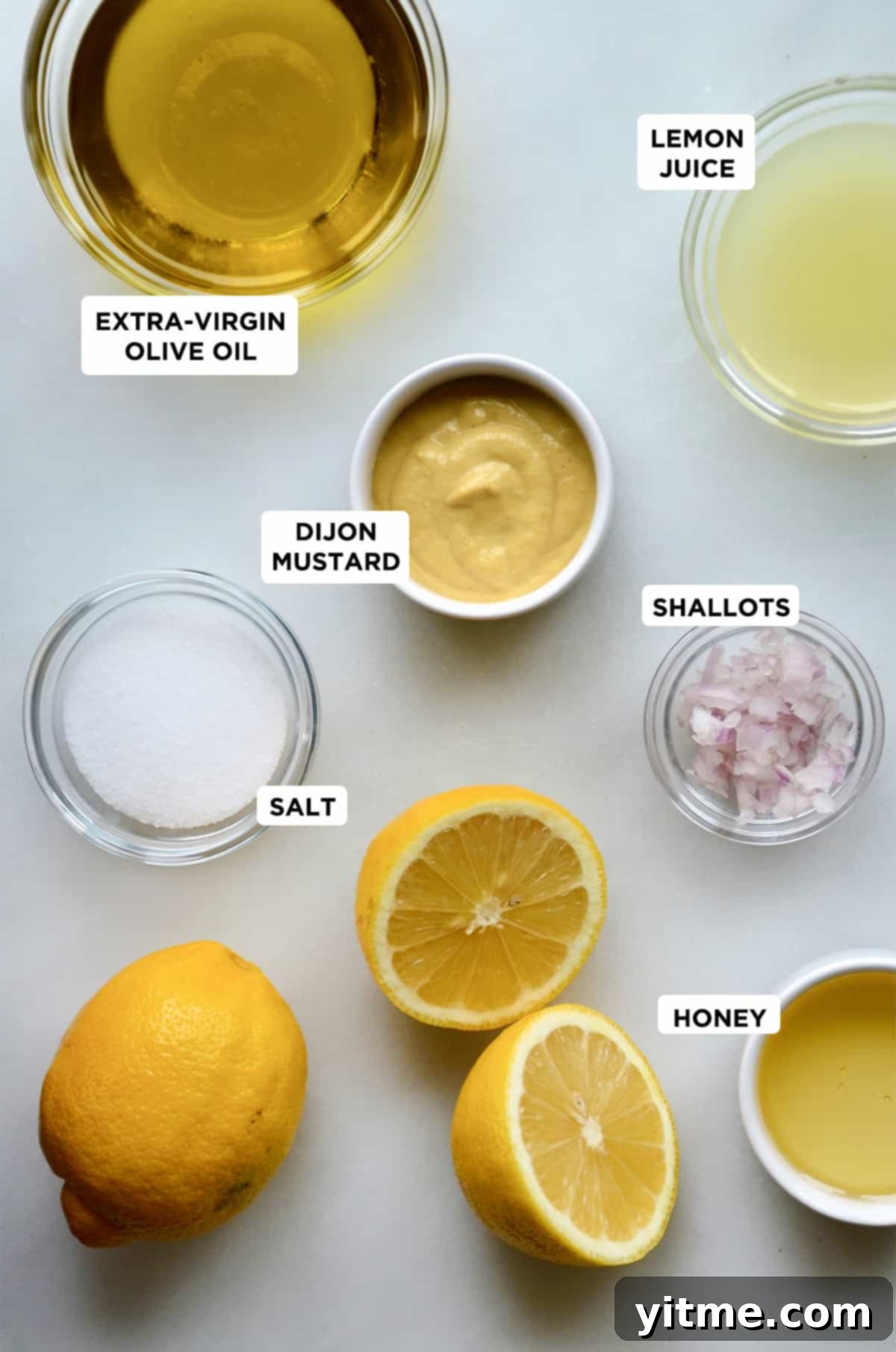 Small bowls of olive oil, mustard, salt, minced shallots, lemon juice, and honey.