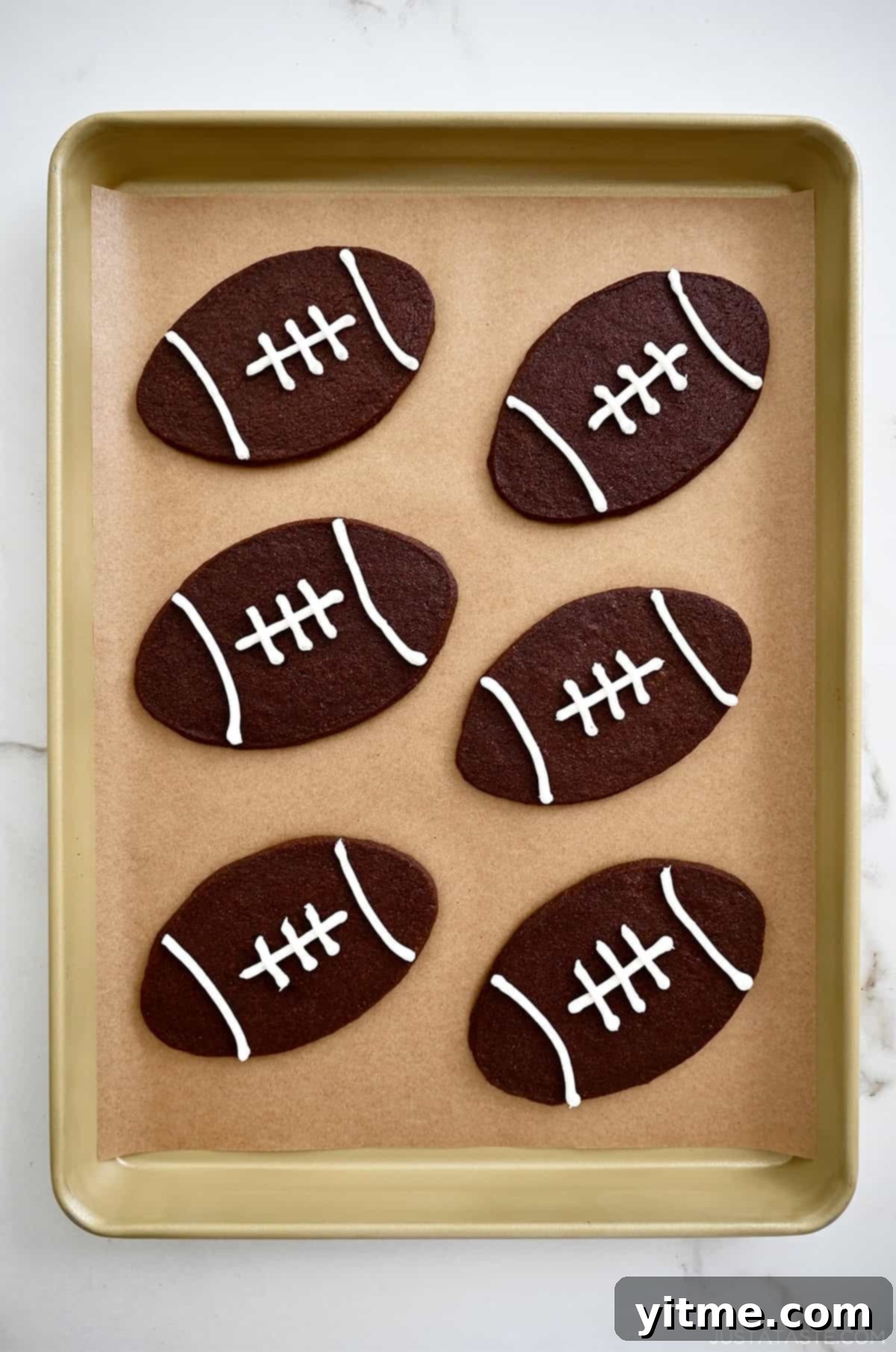 Chocolate football cookies with white icing laces. Perfect delicious snacks.