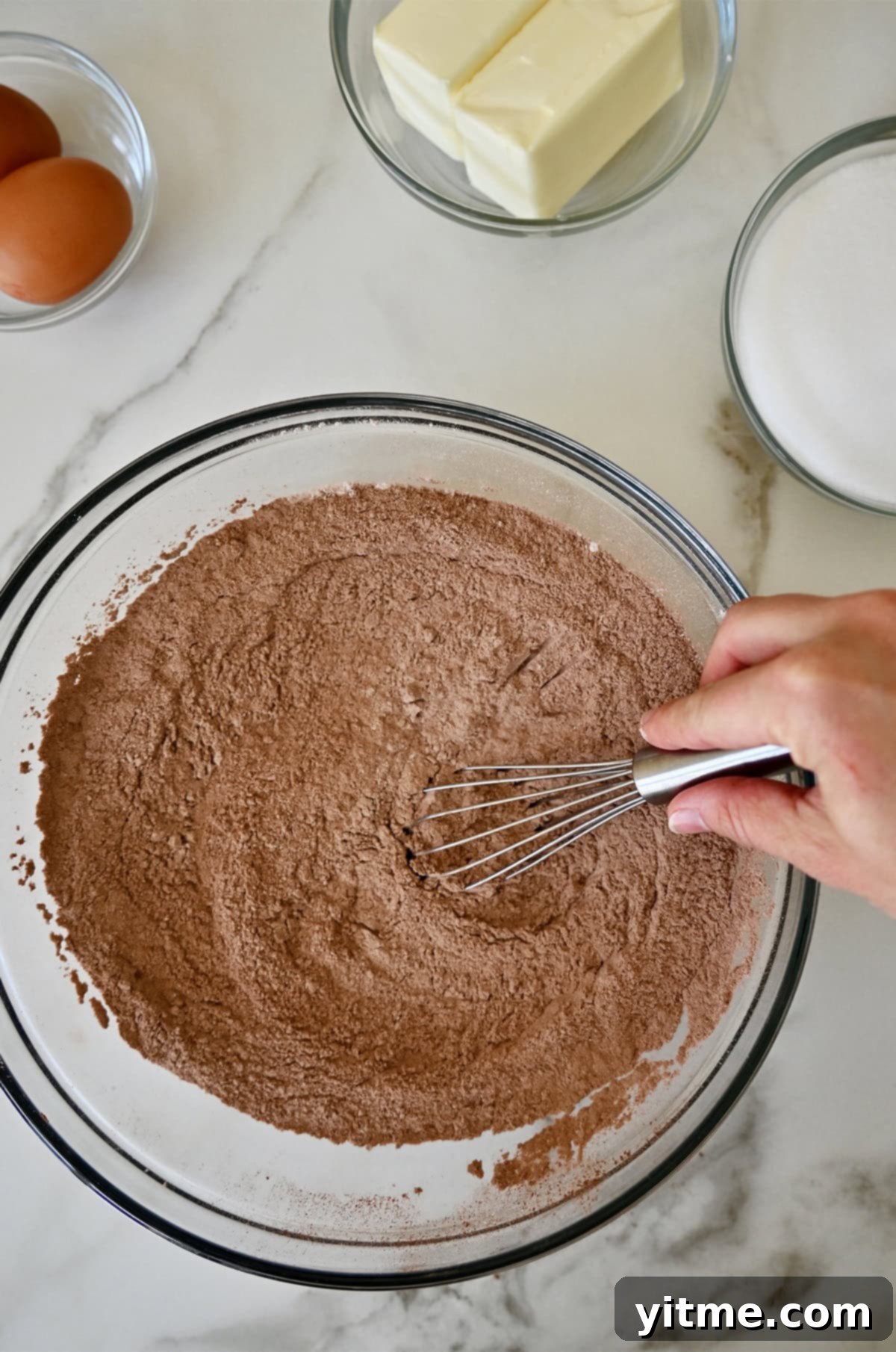 Whisking together flour and cocoa powder. Crucial step to delicious football cookies.