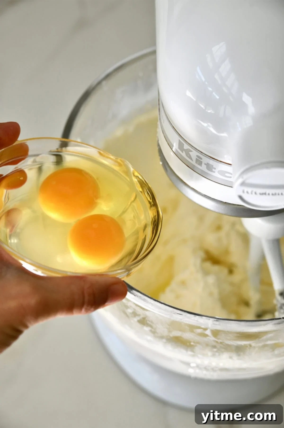 Adding eggs to creamed butter and sugar in a stand mixer. Important for perfectly shaped football cookies.