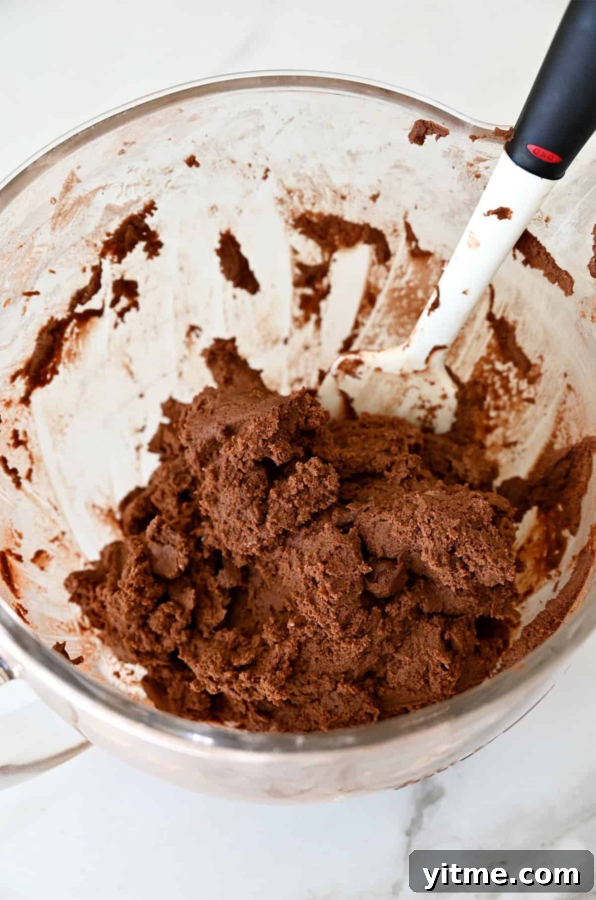 Chocolate sugar cookie dough in a stand mixer bowl. Perfect texture for cutting.