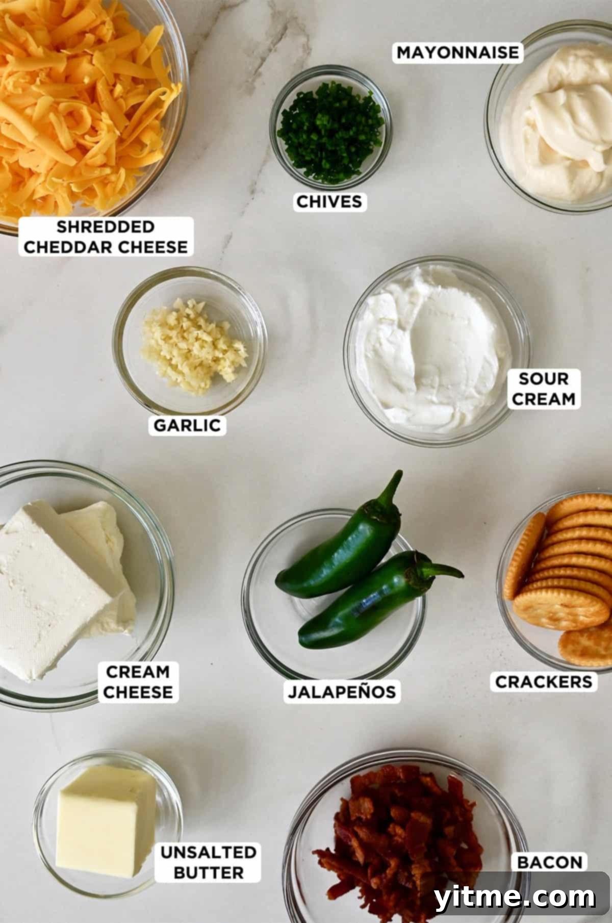 Jalapeno popper dip ingredients in various sizes of glass bowls.