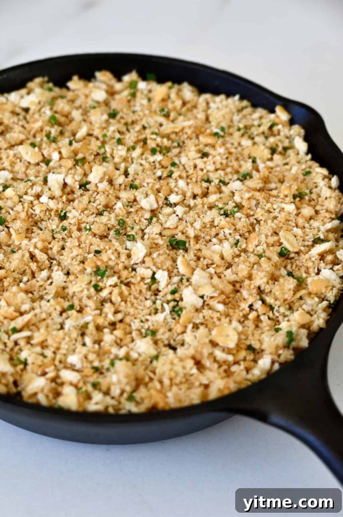 Crushed crackers atop jalapeño dip in a cast iron skillet.