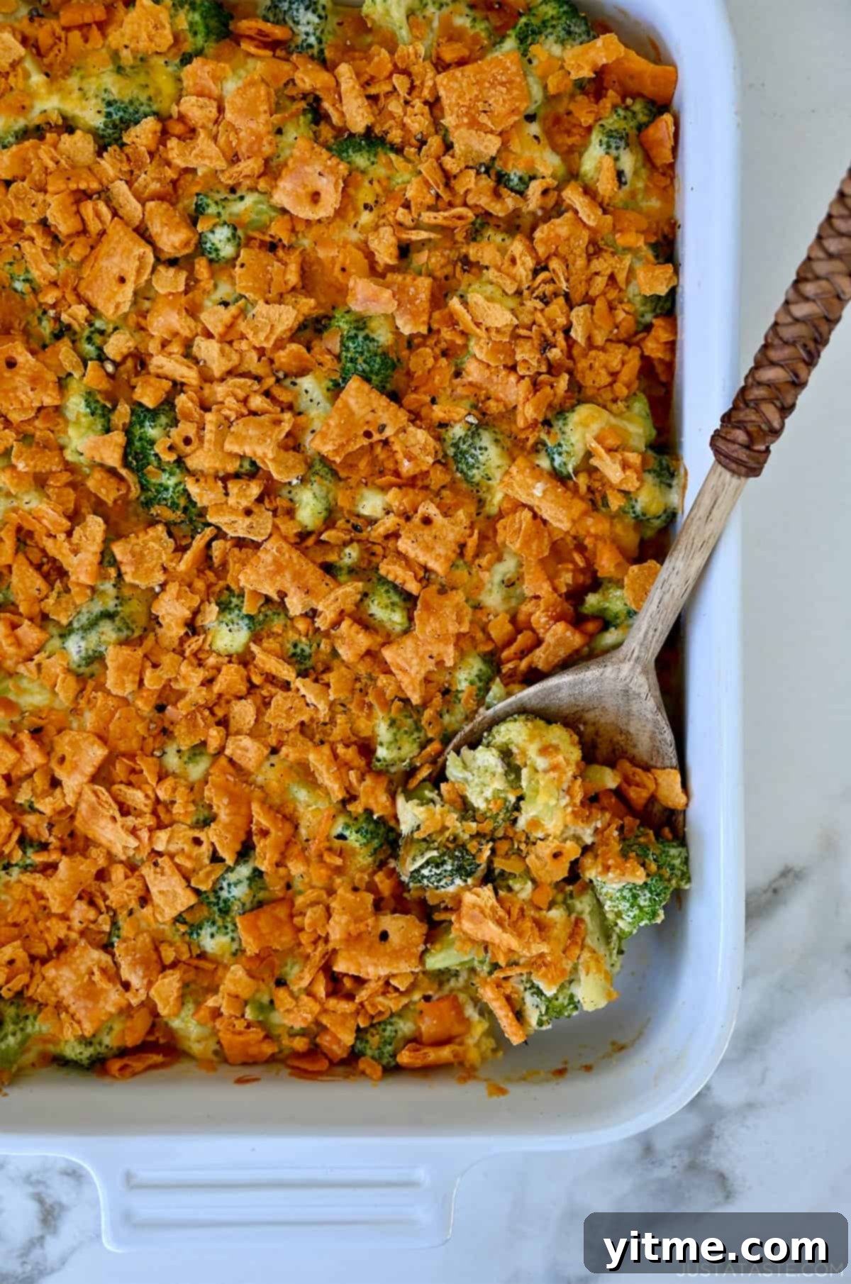 Broccoli cheese casserole topped with cheese crackers in a white casserole dish. A delicious and easy side dish for any occasion.