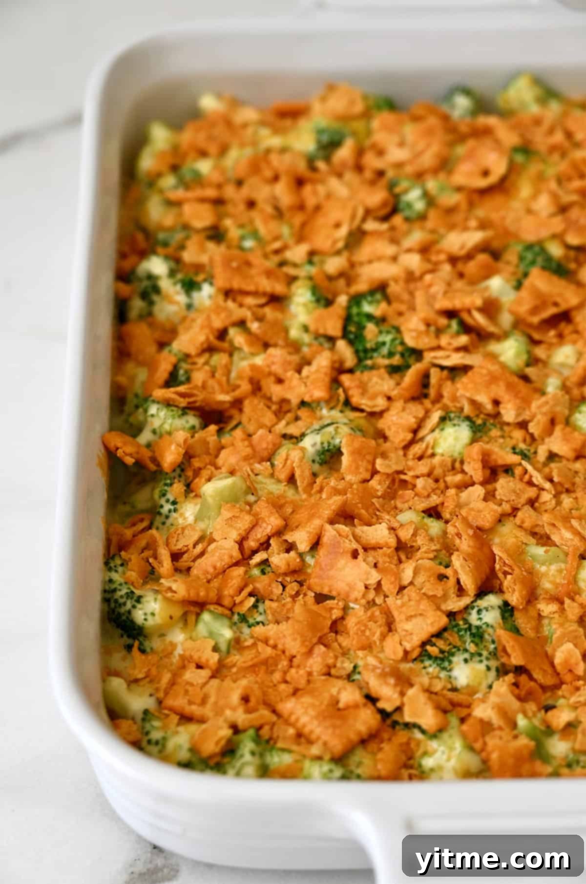 Baked broccoli casserole with cheese and a layer of crushed crackers in a baking dish. A perfect side dish.