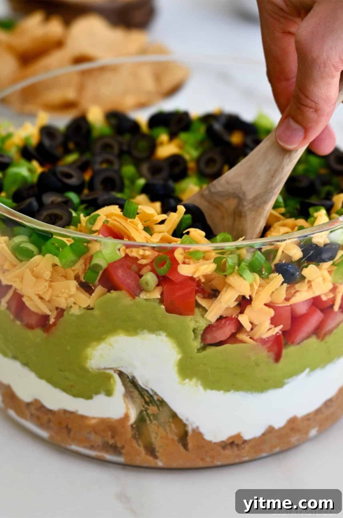 The finished seven layer dip, beautifully layered and ready to be served with tortilla chips.
