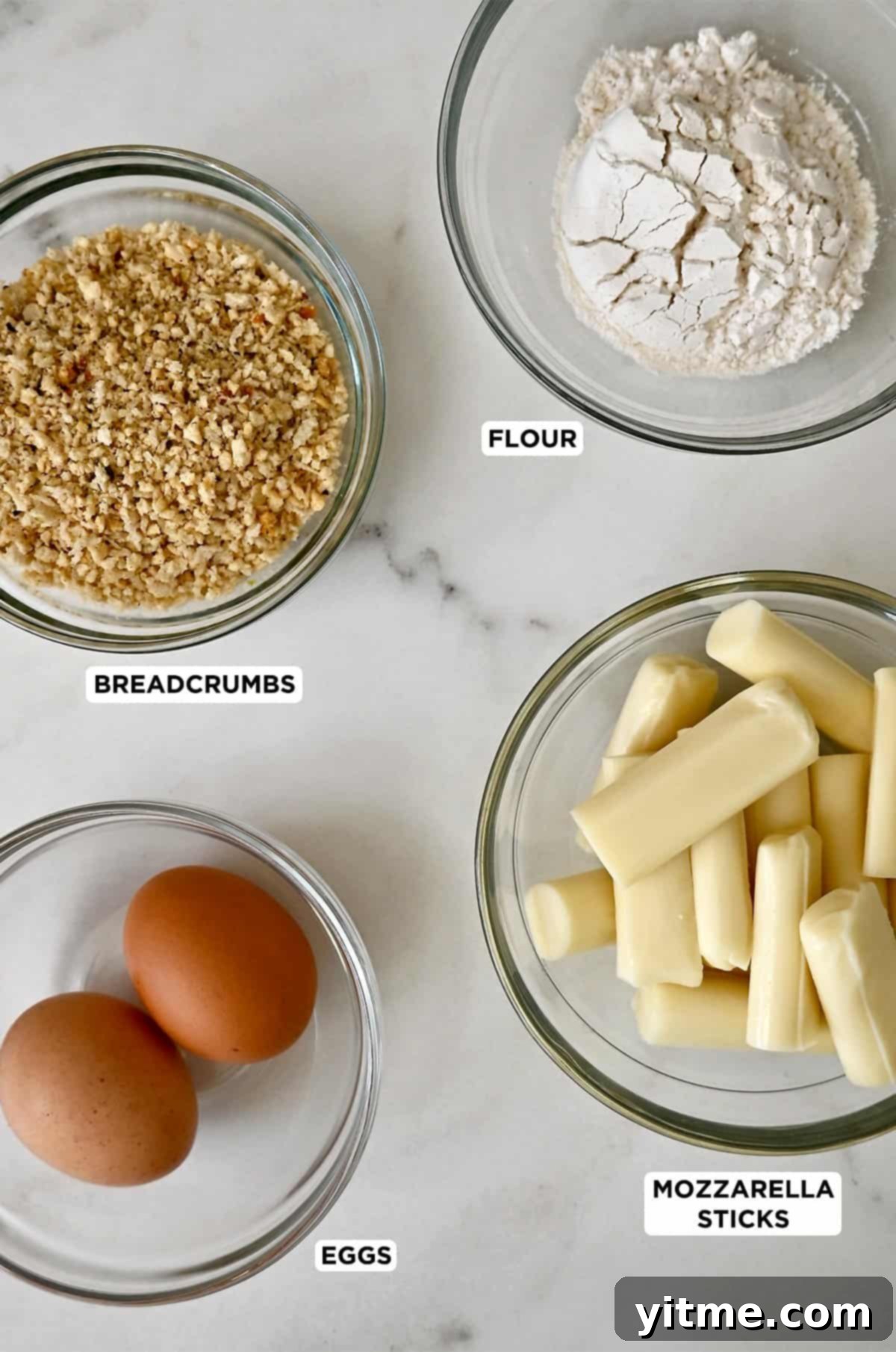 Mozzarella sticks ingredients laid out: String cheese, eggs, breadcrumbs, and flour in separate bowls.