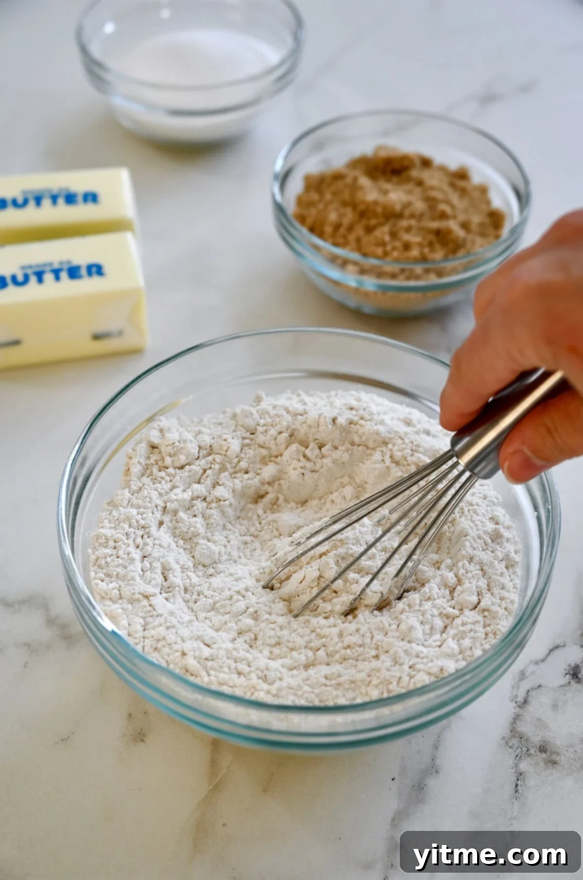 Whisking flour, baking soda, and salt together in a bowl.