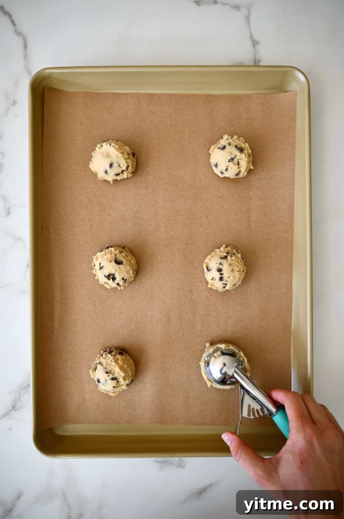 Scooping cookie dough onto a baking sheet.