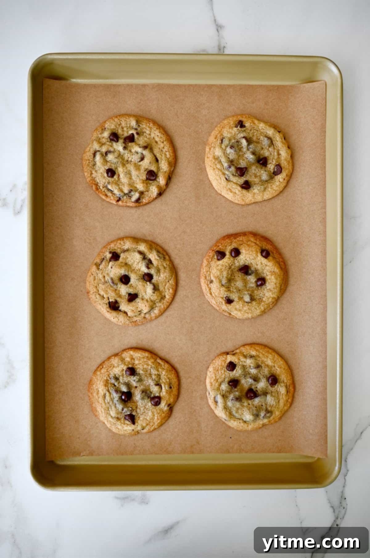 Baked Toll House chocolate chip cookies on a baking sheet.