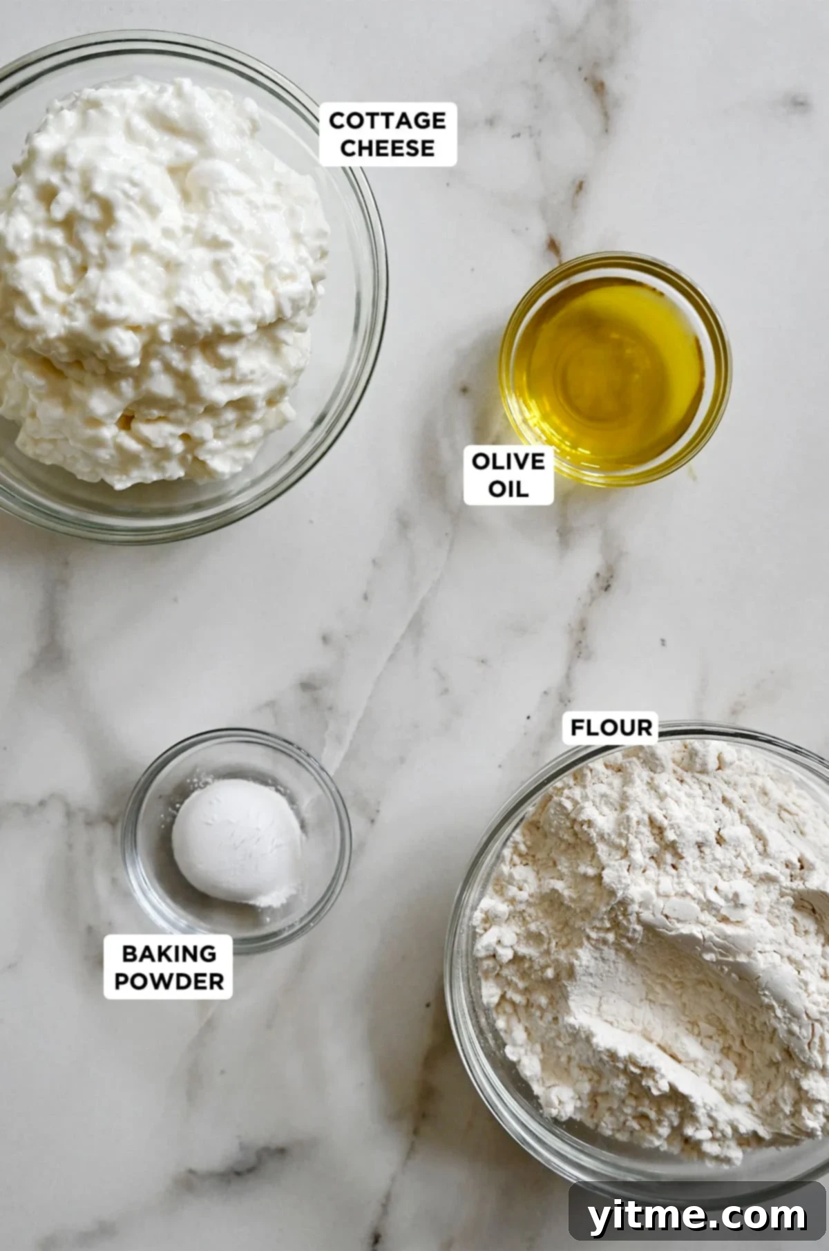 Glass bowls containing cottage cheese pizza dough ingredients: Flour, cottage cheese, olive oil, and baking powder.