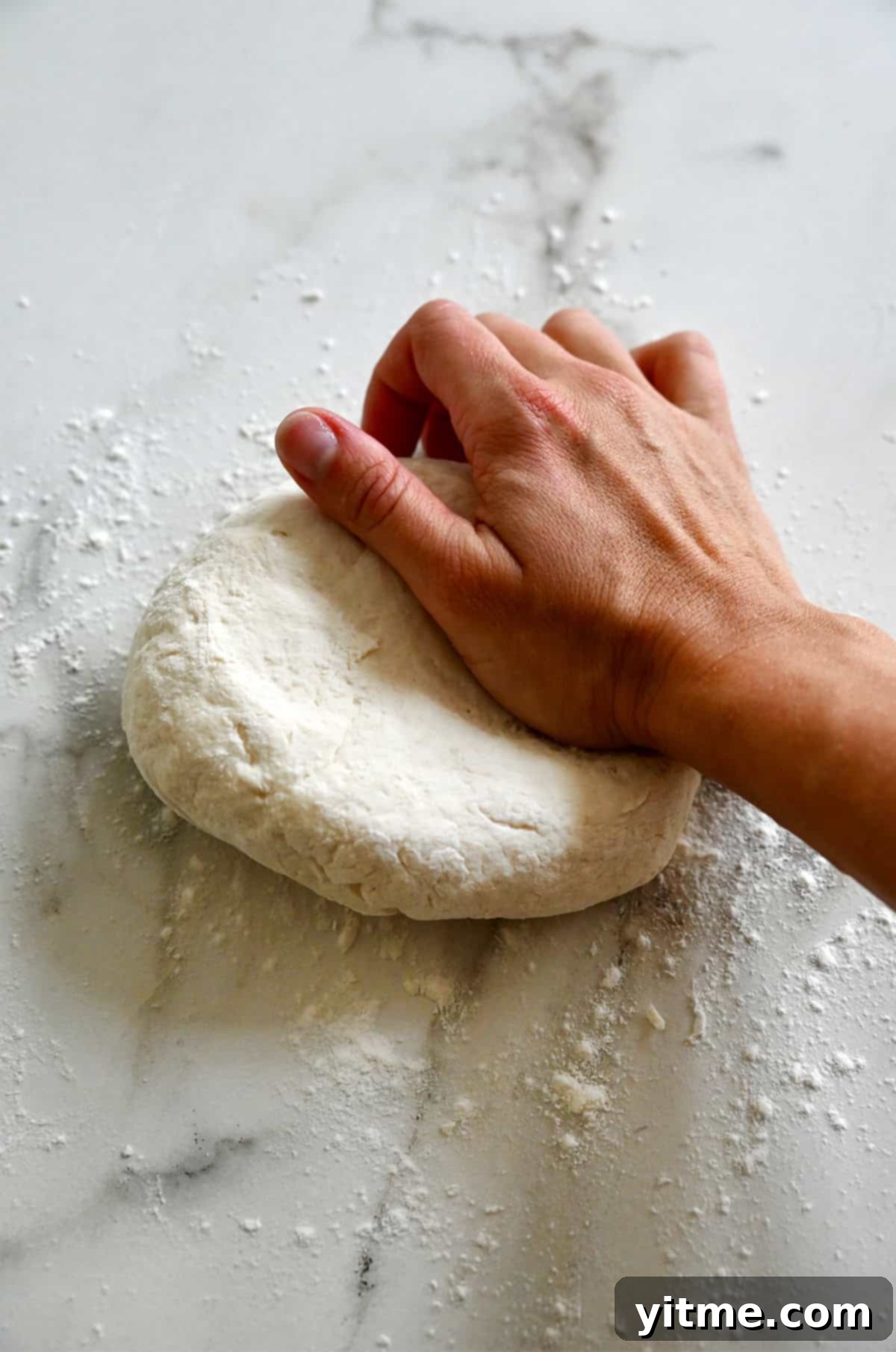 Kneading cottage cheese dough on a lightly floured surface.
