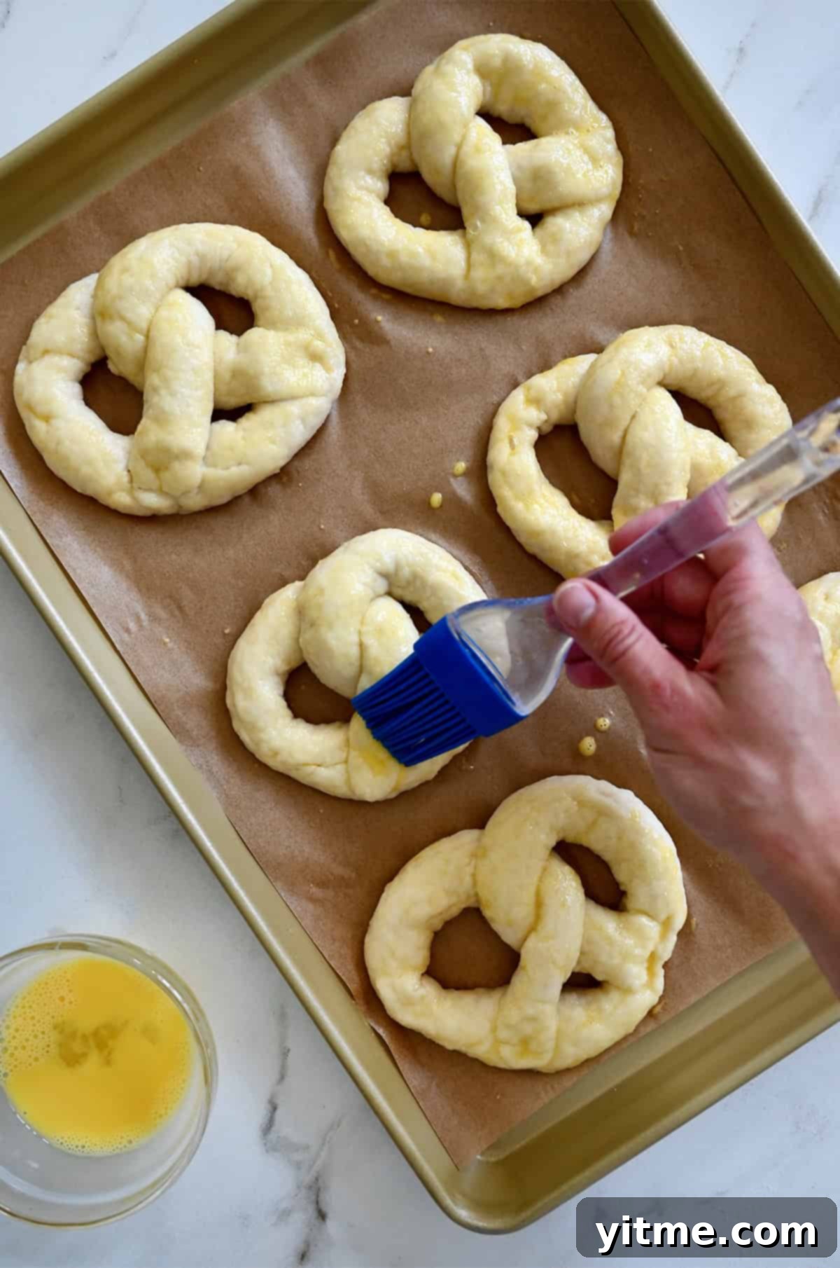 Brushing pretzel dough with egg wash