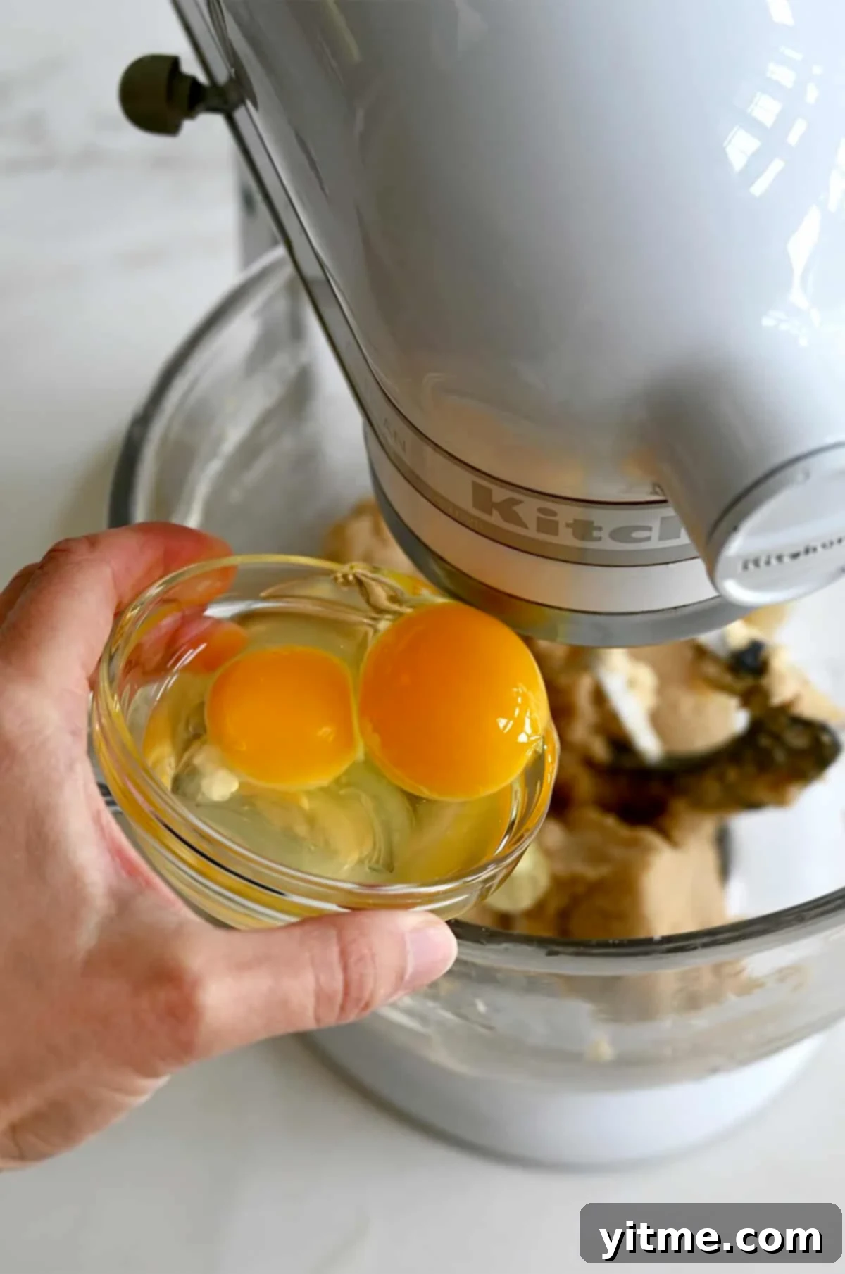 Vanilla Bean Dream Cookies 5 Adding eggs from a small bowl to one with creamed butter and sugar. The glossy sheen of the dough signals the perfect incorporation of ingredients.