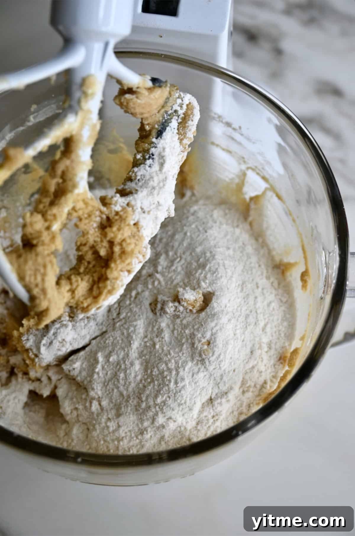 Vanilla Bean Dream Cookies 6 Adding dry ingredients to a large mixing bowl with creamed butter, sugar, eggs and vanilla extract. A blend of wet and dry creating the foundation of our cookies.
