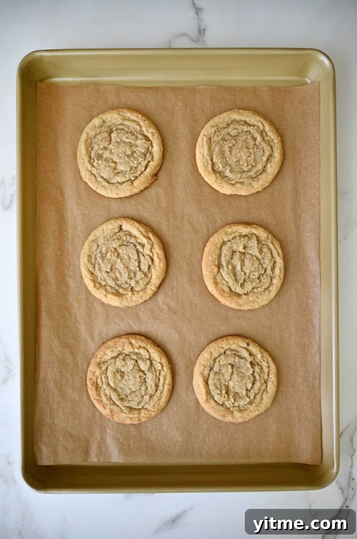 Vanilla Bean Dream Cookies 9 Golden brown chocolate chipless cookies on a parchment paper-lined baking sheet fresh out of the oven. The perfect balance of golden edges and soft centers.