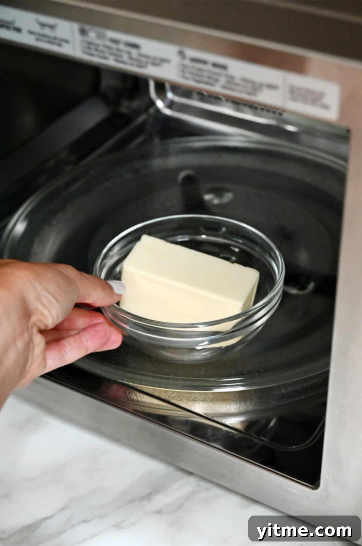 Microwaving butter carefully to soften it.