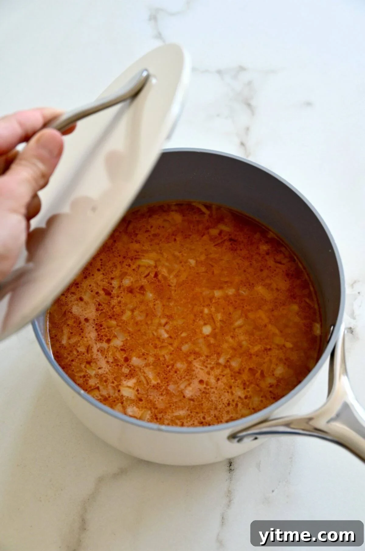 Vibrant Mexican Rice: A Flavorful Fiesta 7 Simmering Mexican rice with a lid