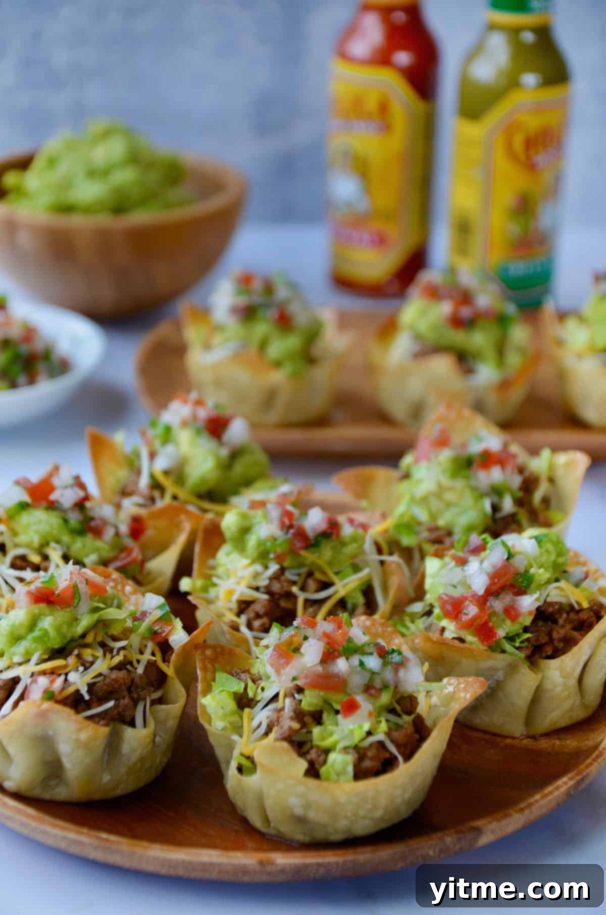 Taco salad cups in wonton wrappers on a serving platter.