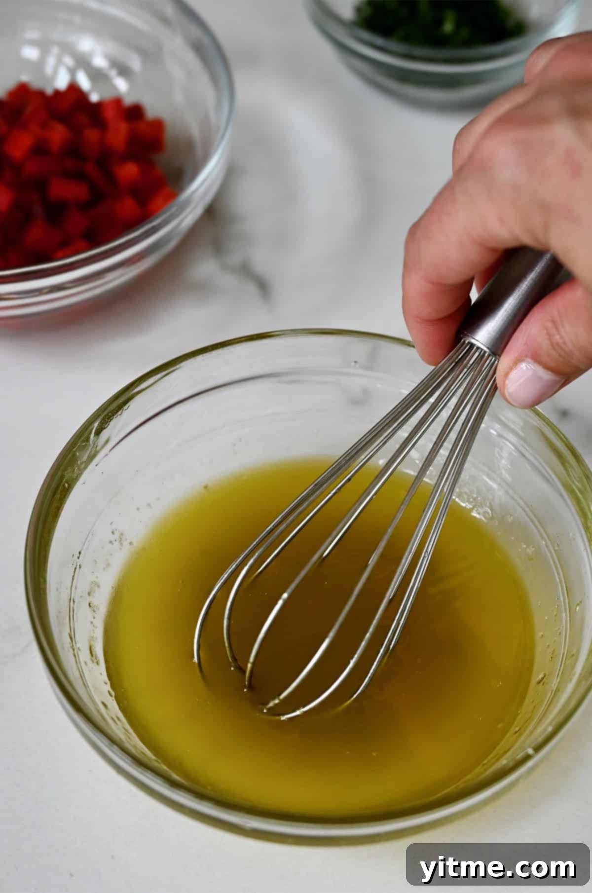Honey lime dressing being whisked in a bowl.