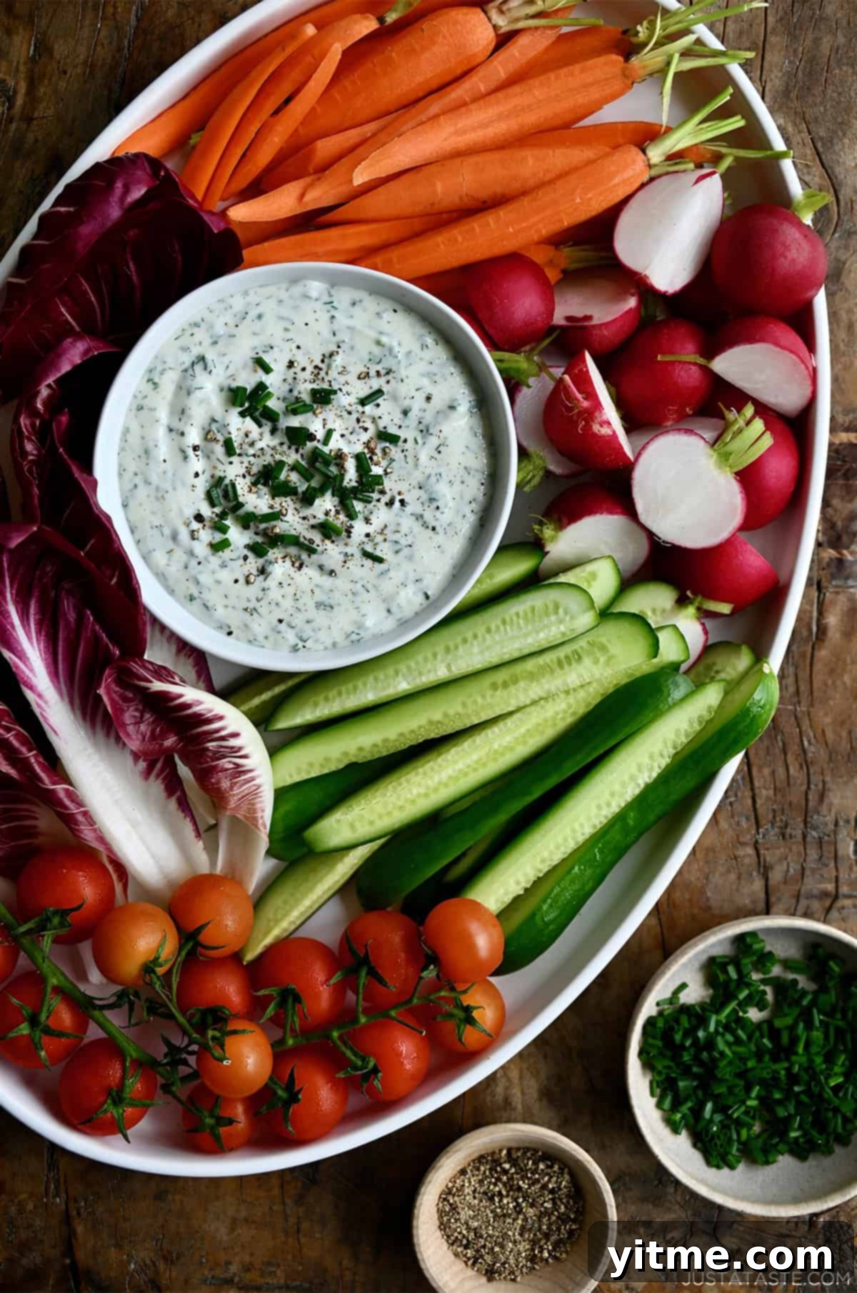 High protein cottage cheese veggie dip in a small bowl on a serving platter surrounded by fresh veggies.