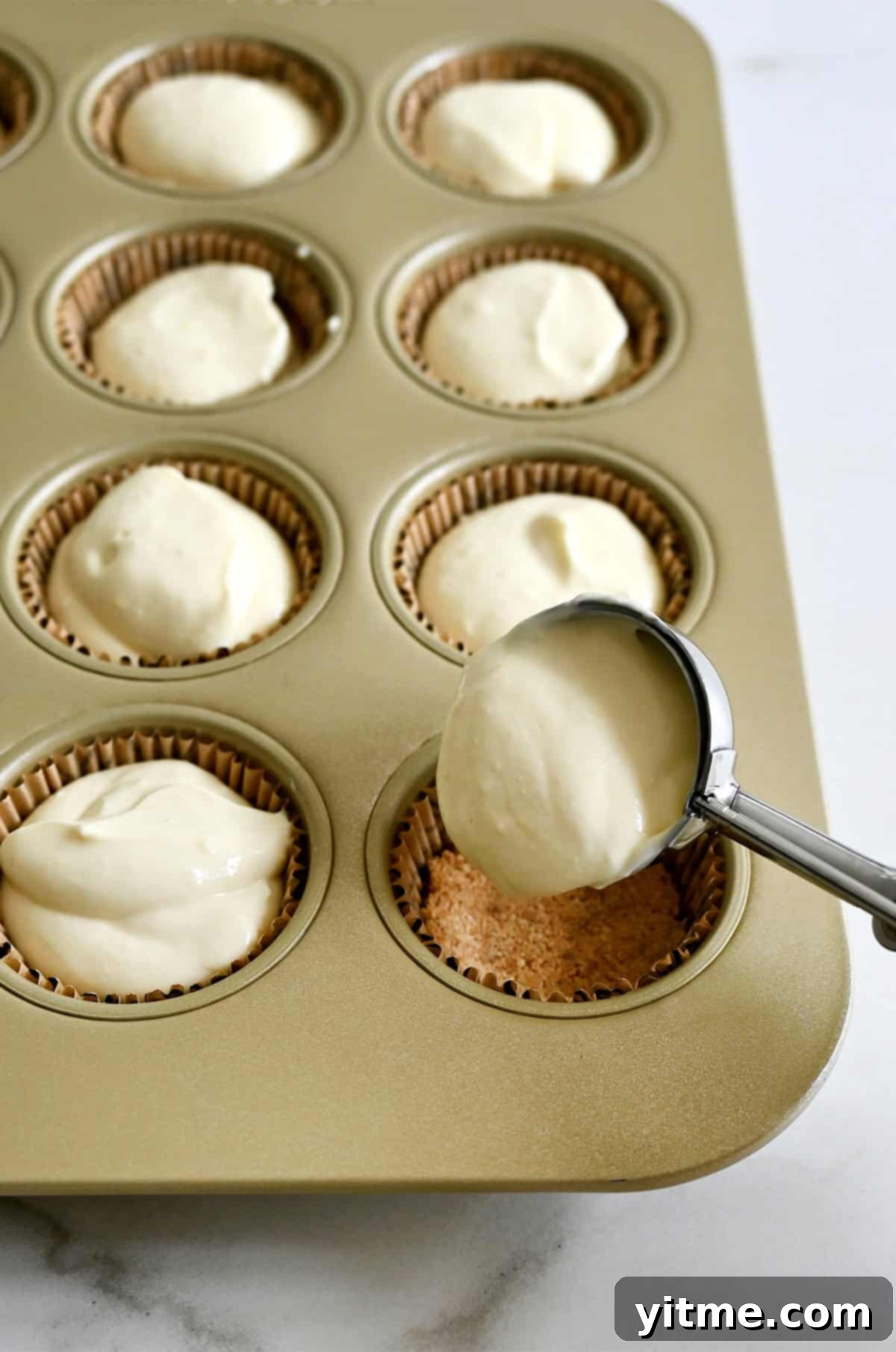 Filling muffin tin with cheesecake batter