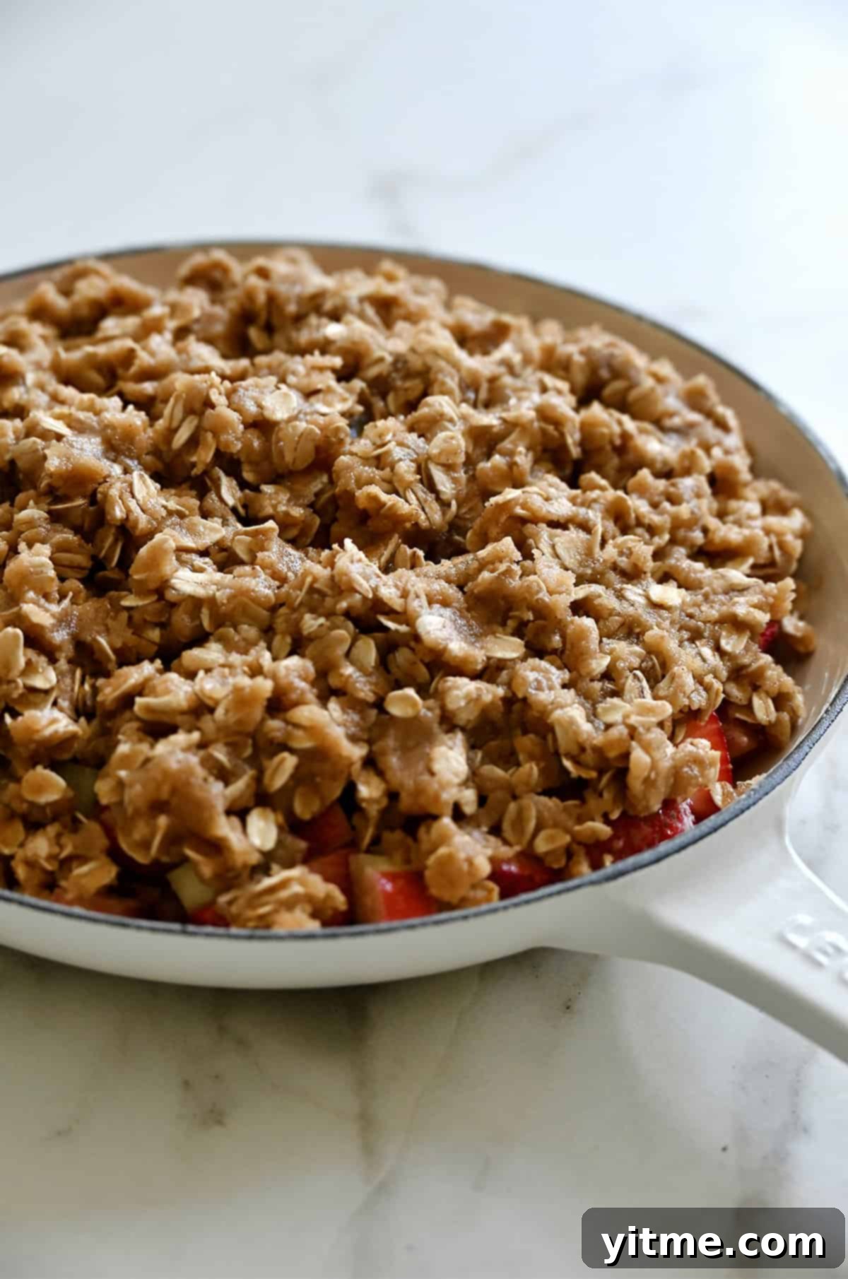 An unbaked fruit crisp in an oven-safe skillet.