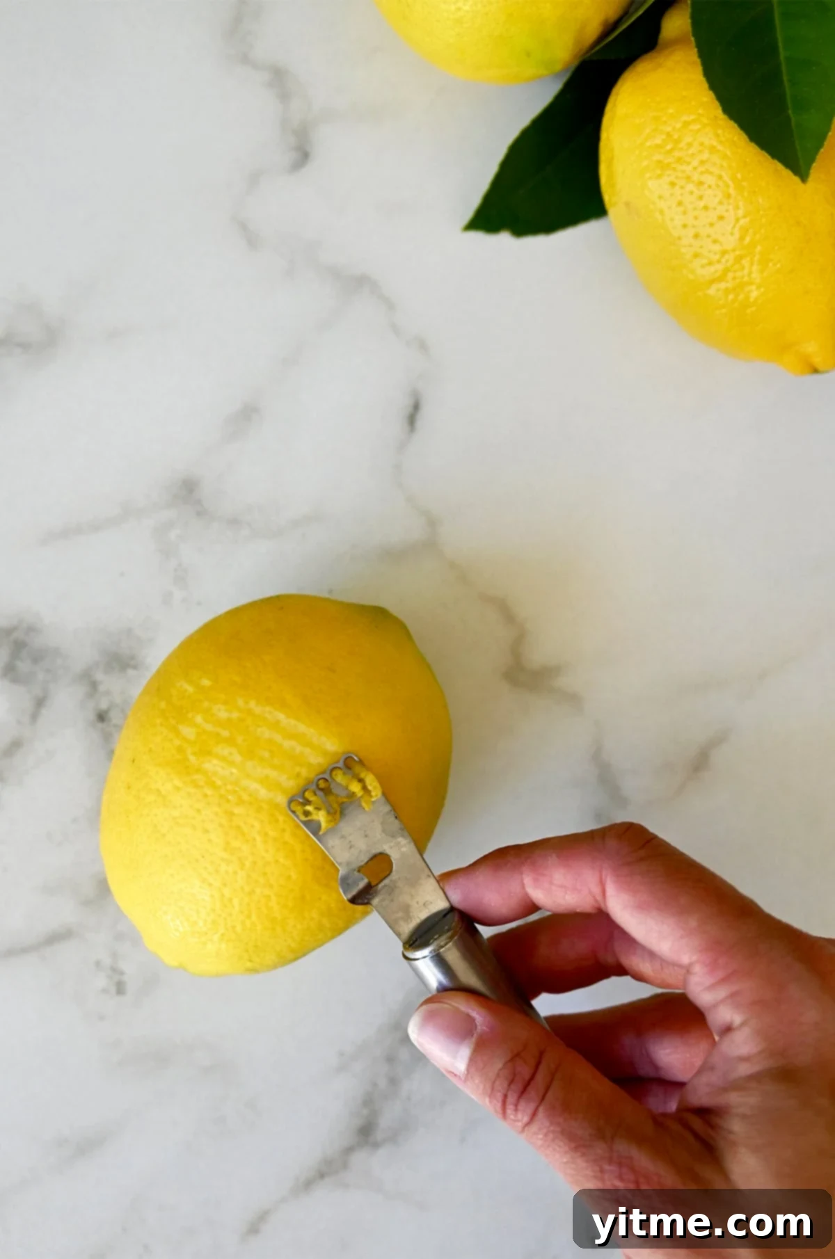 Zesting Lemons: A Citrus Twist Guide 5 Demonstration of zesting a lemon with a traditional citrus zester.