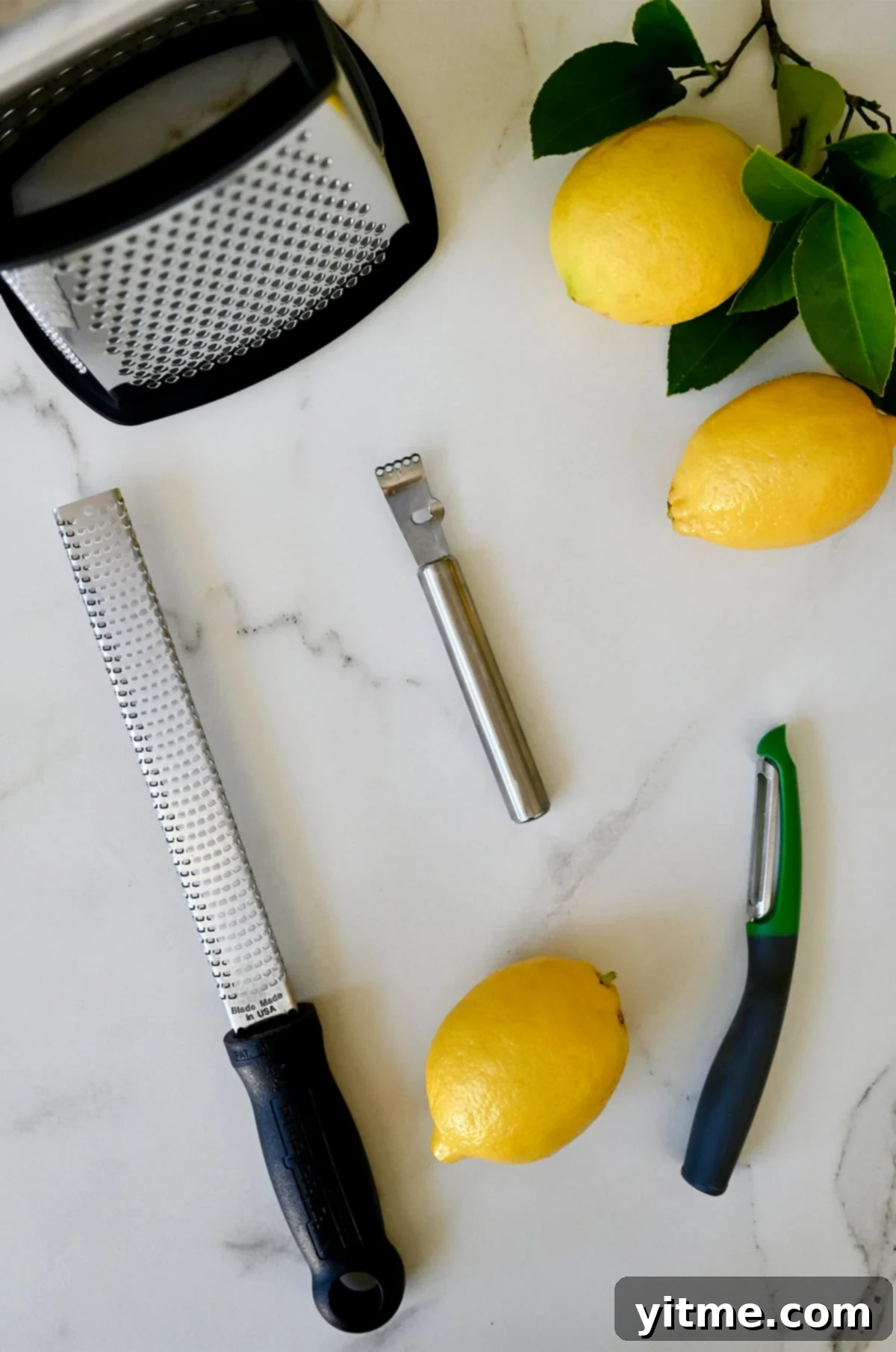 Zesting Lemons: A Citrus Twist Guide 7 Arrangement of lemons alongside a box grater, microplane, vegetable peeler, and citrus peeler.
