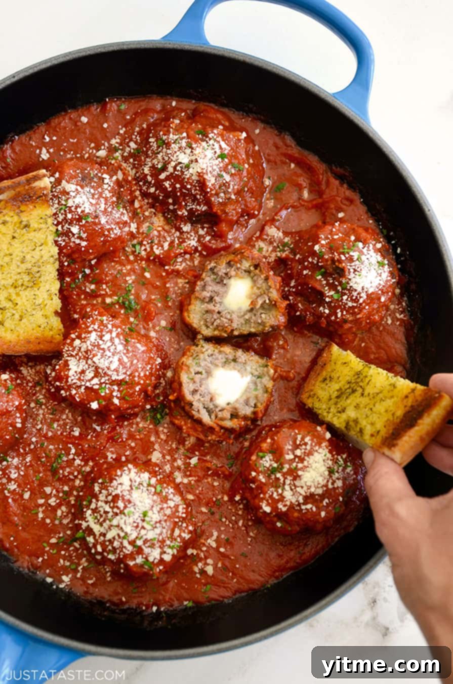 A skillet containing Cheese-Stuffed Meatballs with Garlic Bread Dippers