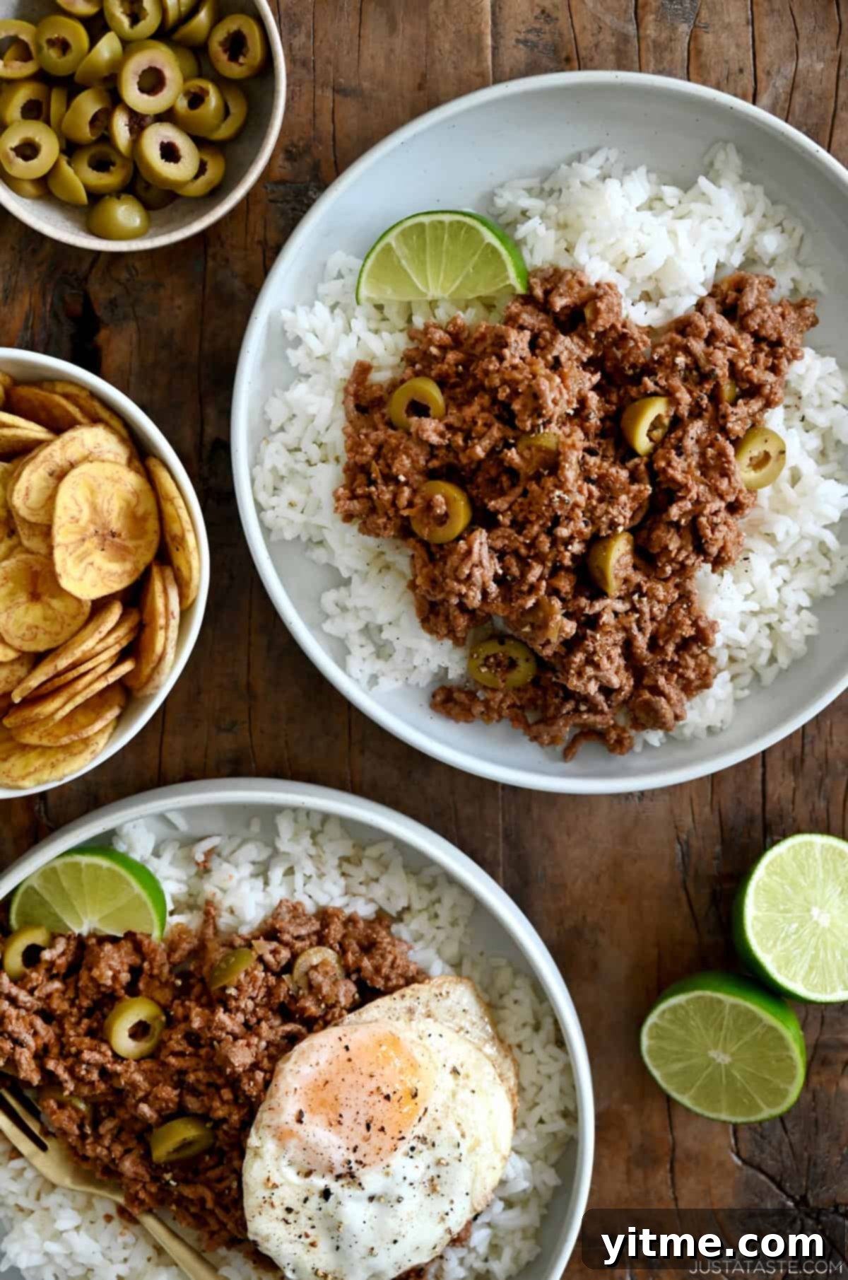 Two plates featuring fluffy white rice topped with savory Cuban Picadillo and a perfectly fried egg. This flavorful dish is a one-pot wonder, offering a comforting and satisfying meal.