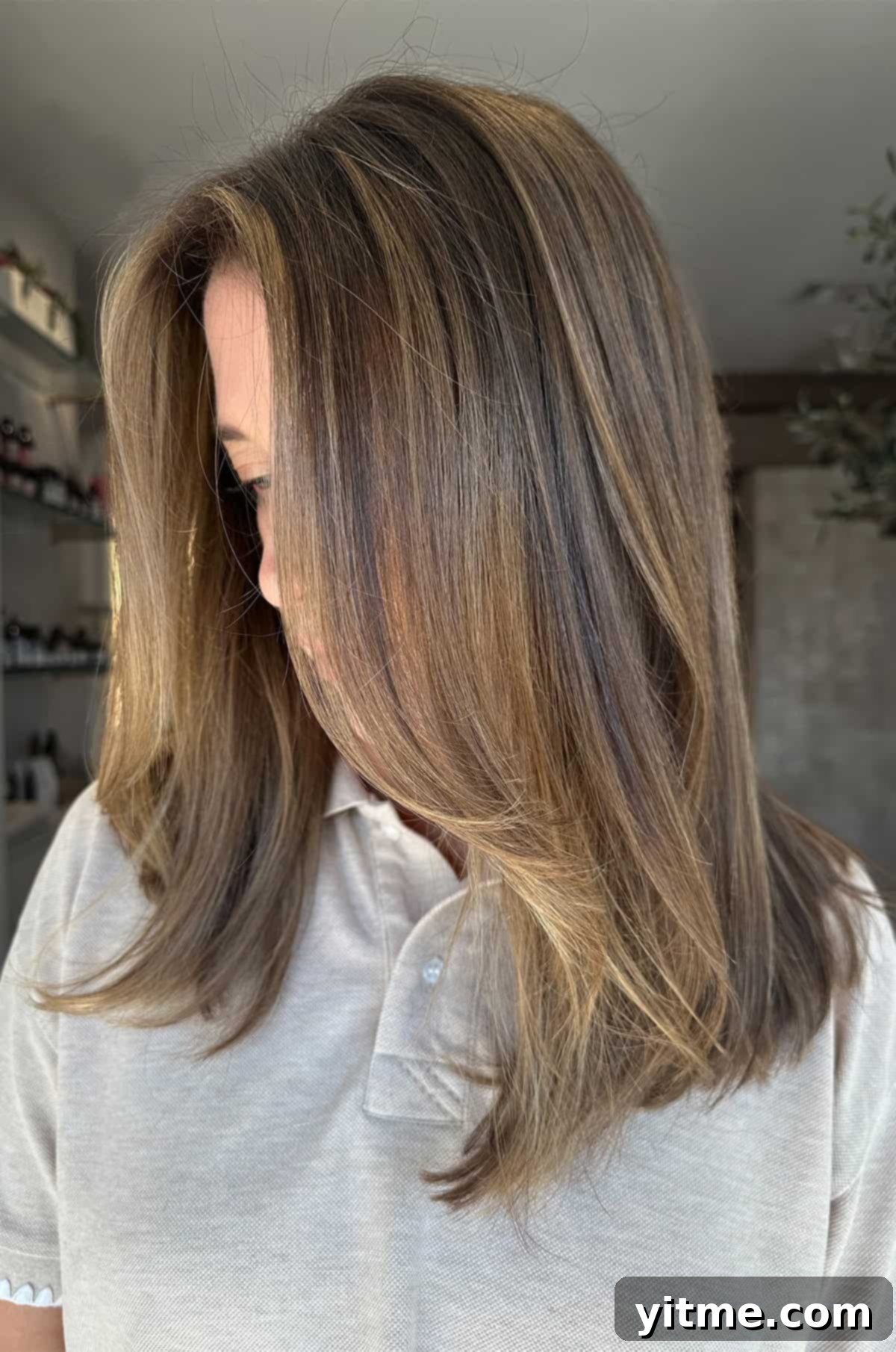 A light brunette color and haircut profile view - Showcasing a revitalized hairstyle after postpartum hair changes.