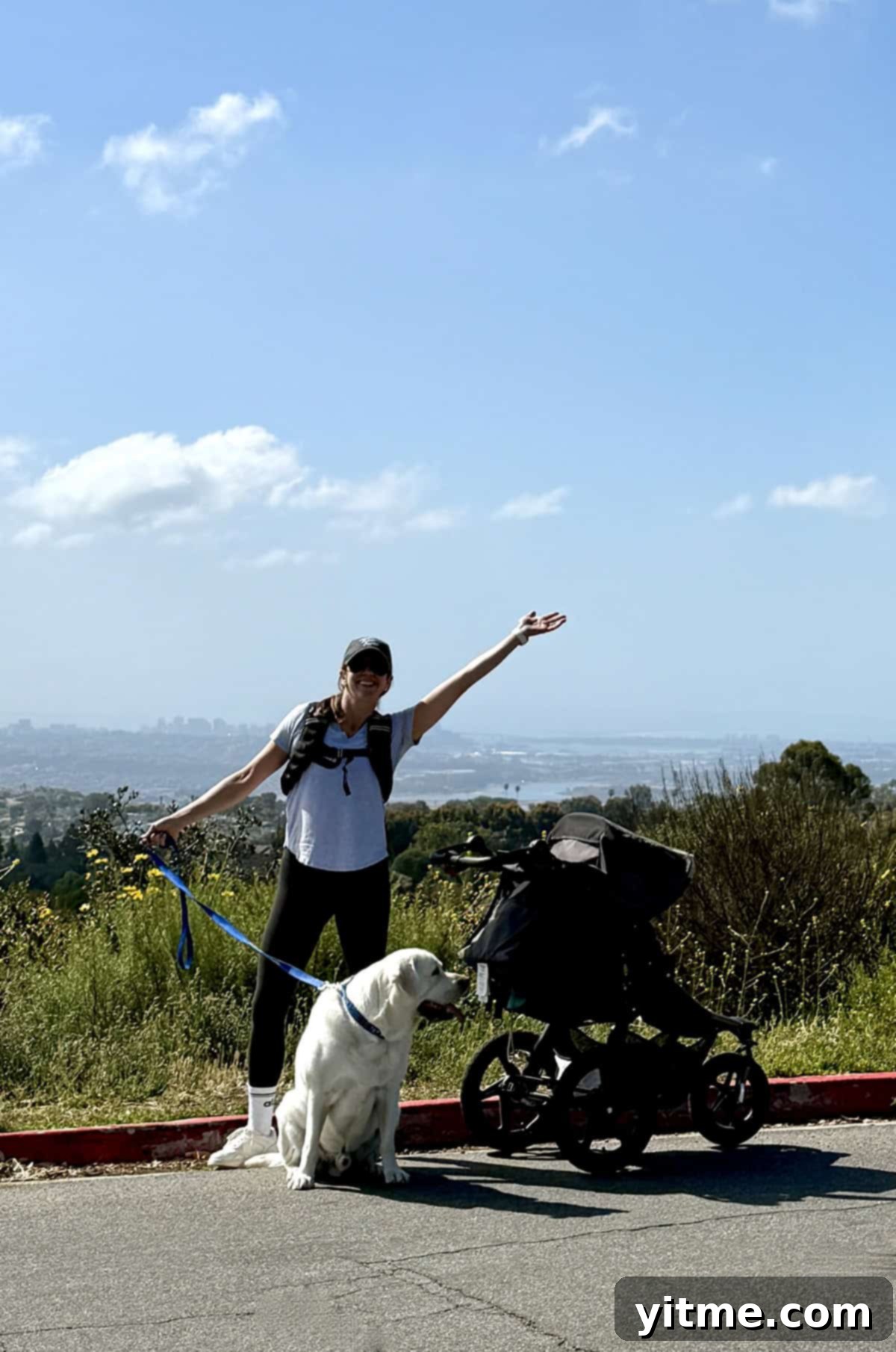 A woman holding a dog leash while rucking with a stroller - Combining fitness with everyday activities for busy moms.
