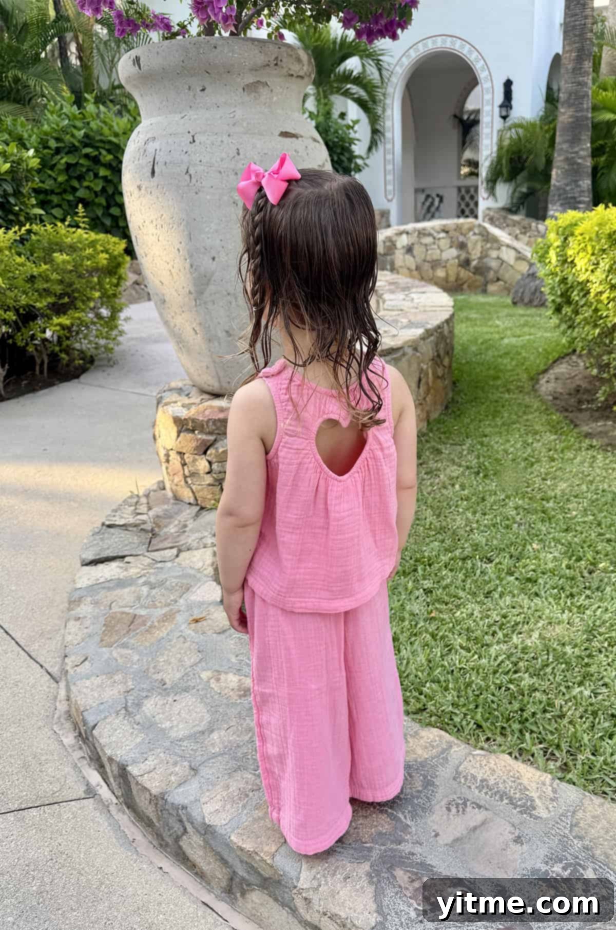 The back of a little girl's head with a pink bow and braid - Showcasing a stylish and well-dressed child.