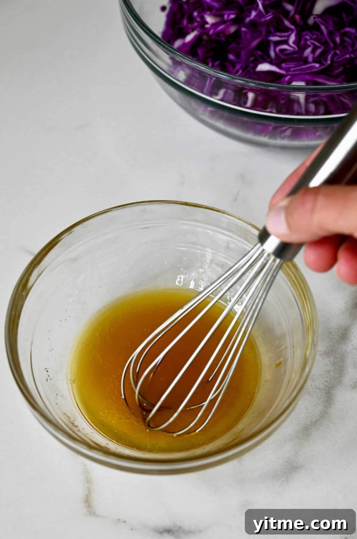 Small bowl with Asian dressing ingredients: sesame oil, fish sauce, olive oil, sugar, and fresh lime juice, whisked together.