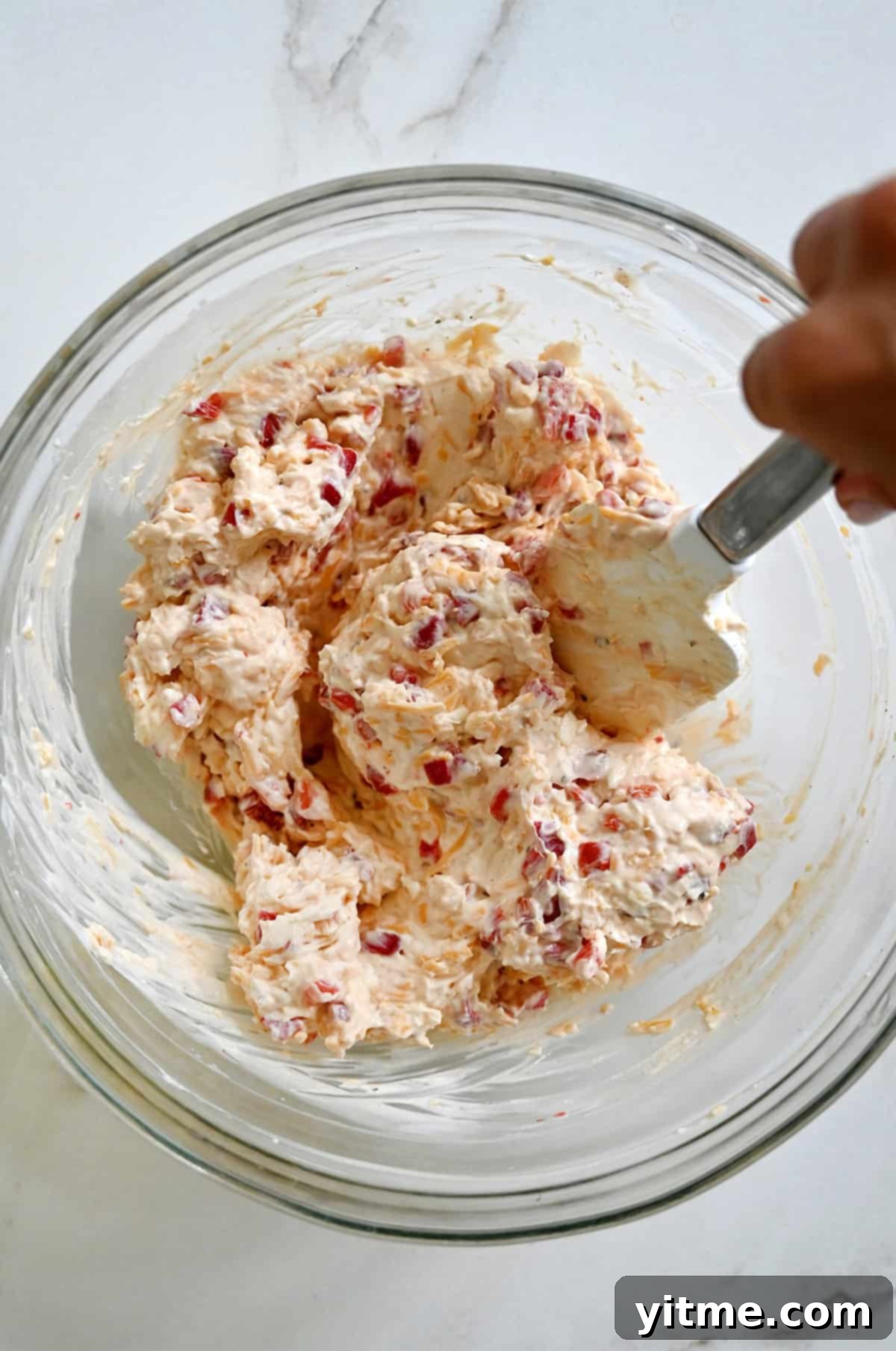 Mixing pimento cheese ingredients in a bowl