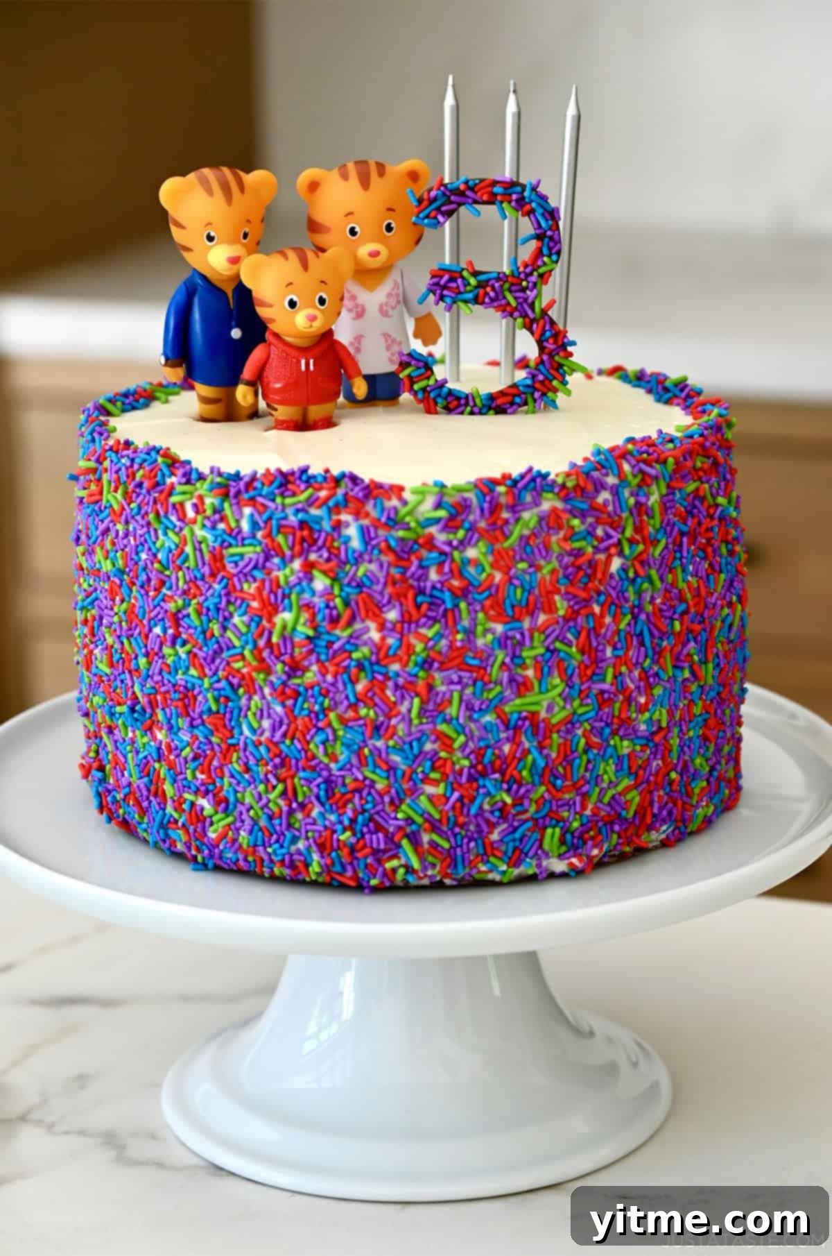 Kelly's Monthly Edit: July 2025 3 A young girl, Mia, smiling brightly as she celebrates her third birthday, surrounded by balloons and festive decor, looking joyful and ready for cake.