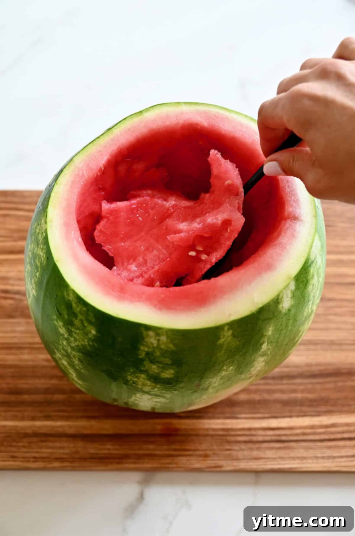 Scooping out the center of a watermelon.
