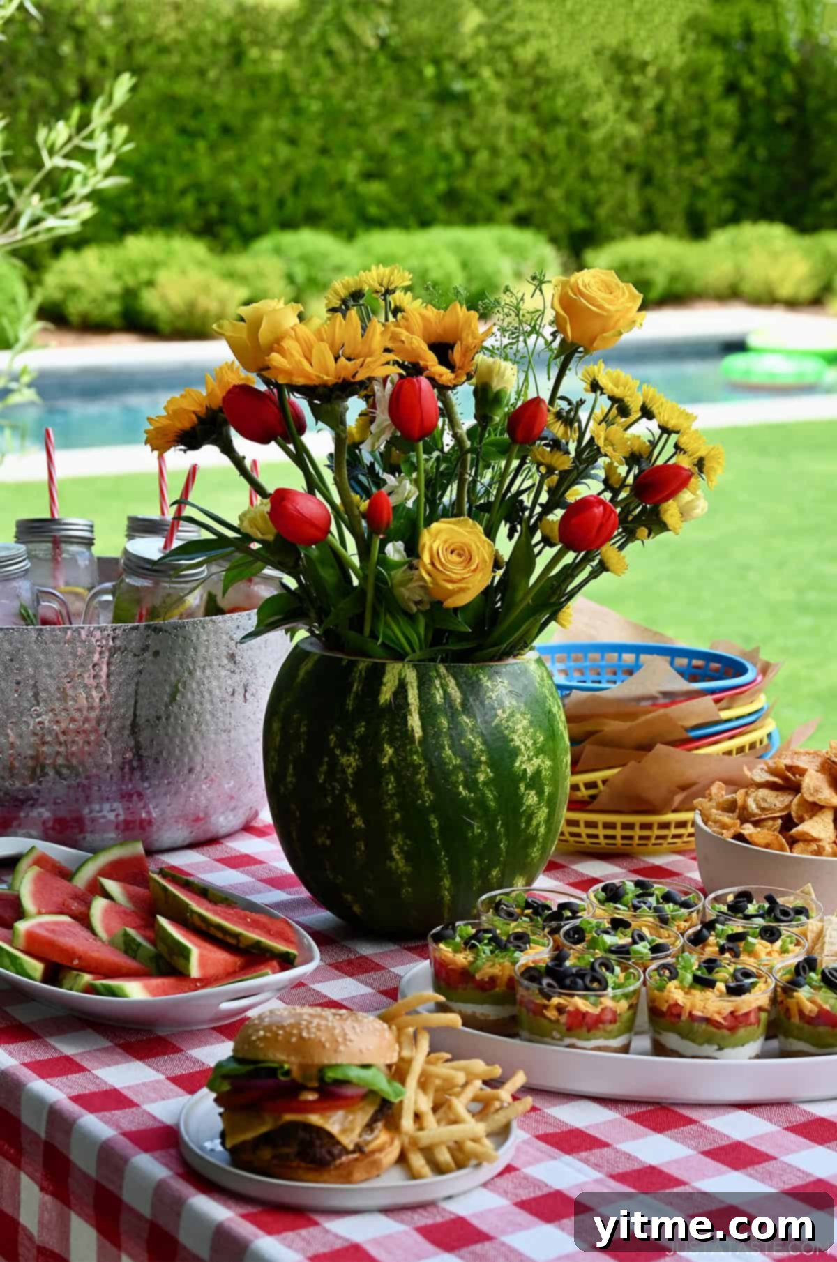 Watermelon centerpiece on a table lined with a red and white-checkered tablecloth.