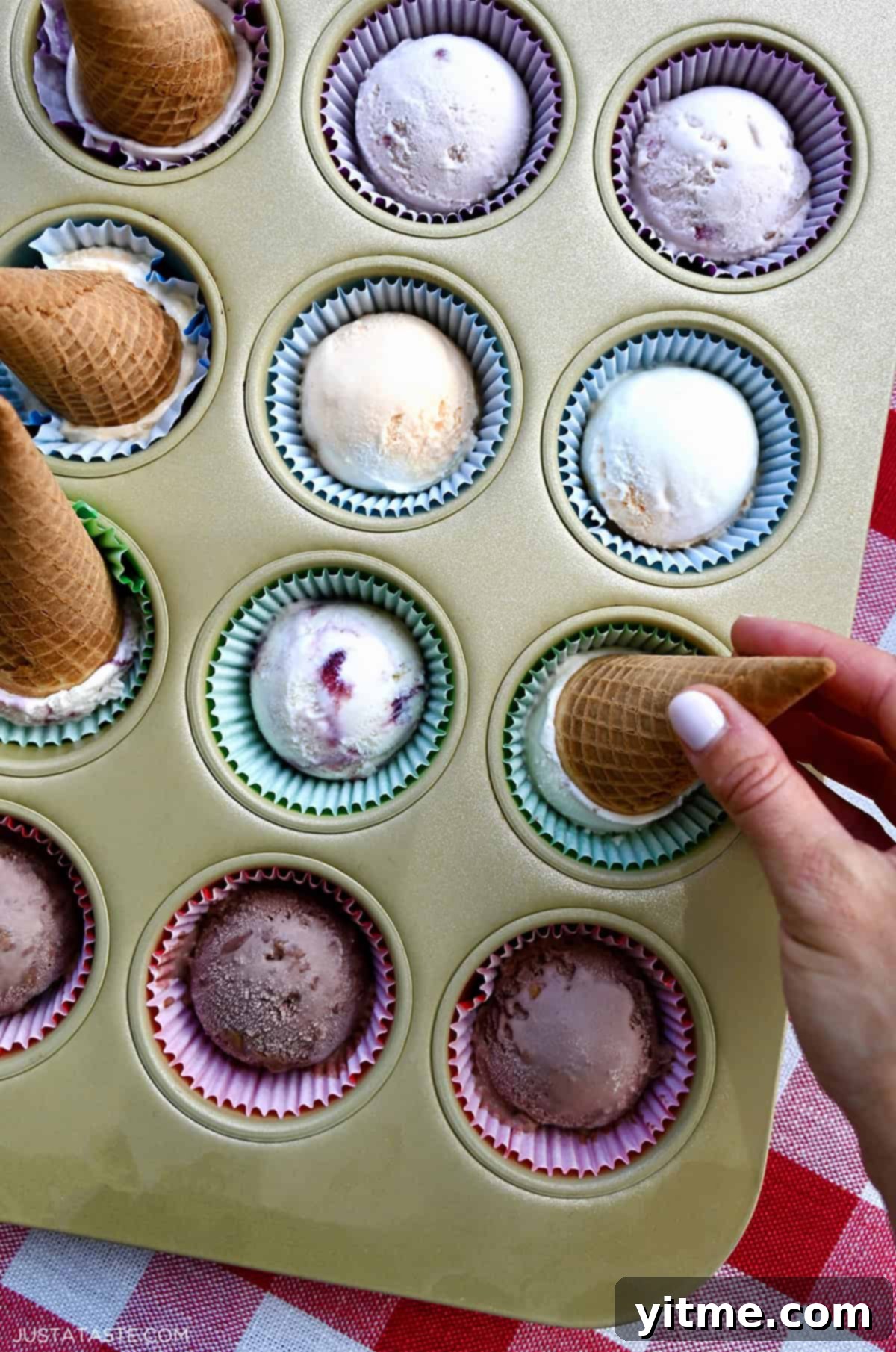 Pre-scooped ice cream in a muffin tin lined with cupcake liners.