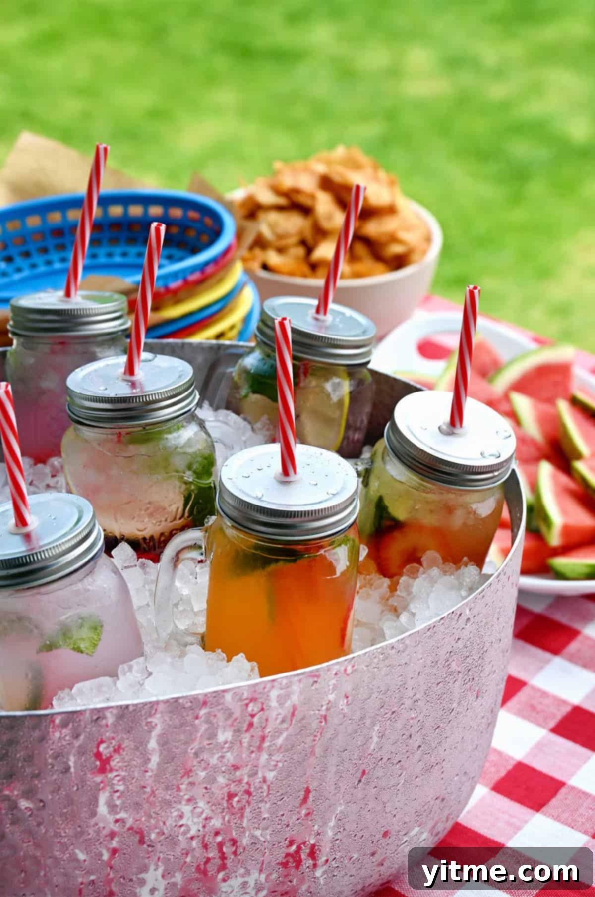 Pre-batch cocktails in mason jars sitting in a tub filled with ice.