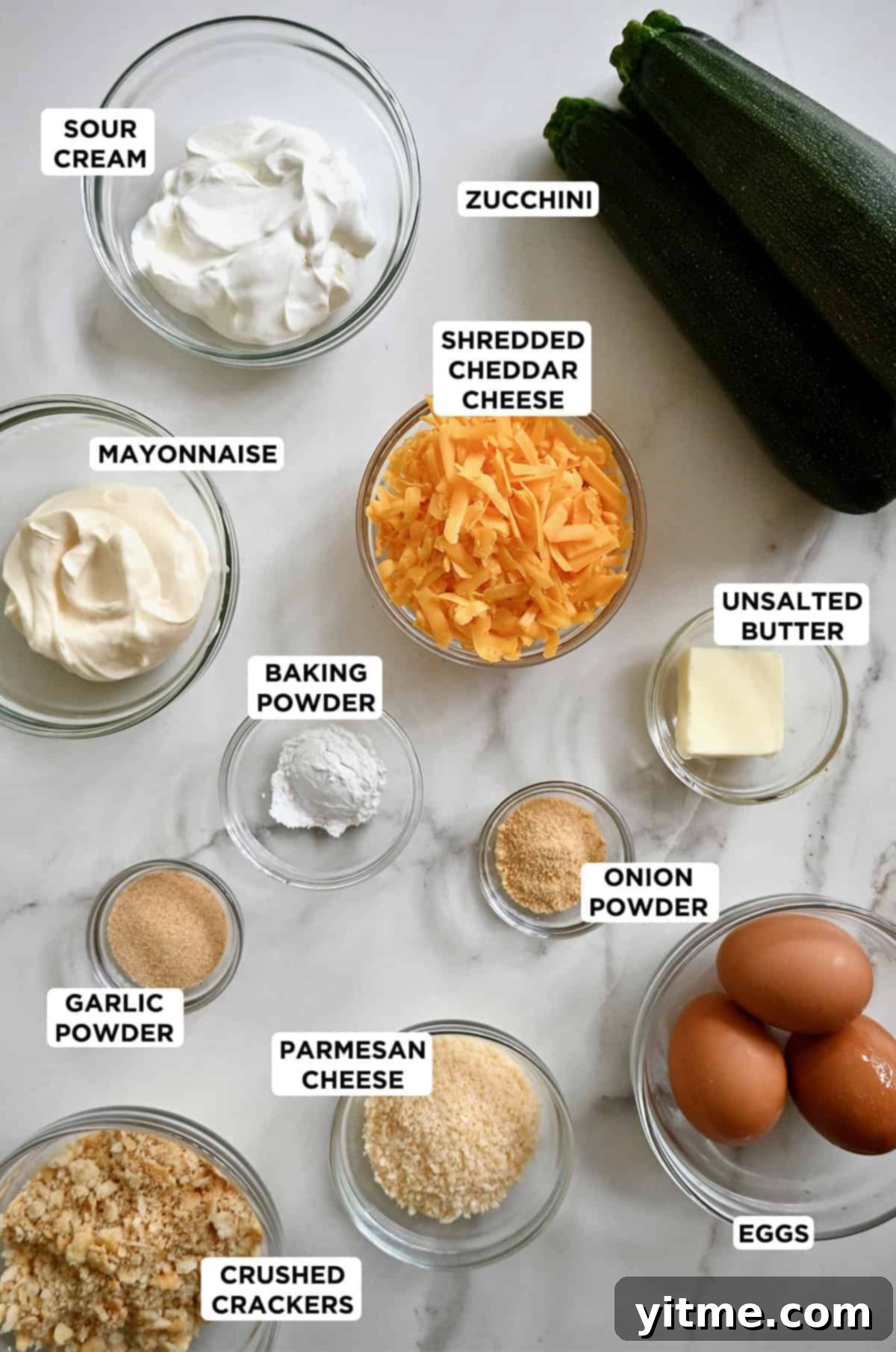Ingredients for cheesy zucchini casserole, including zucchini, sour cream, mayonnaise, and cheese.