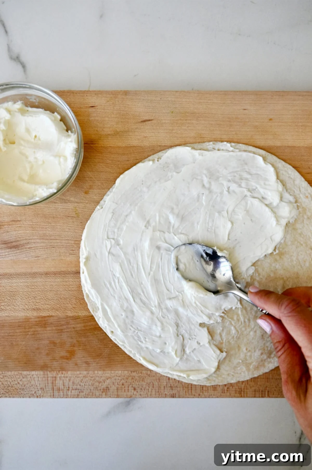 Swirl Sandwiches 4 Spreading cream cheese on a flour tortilla.