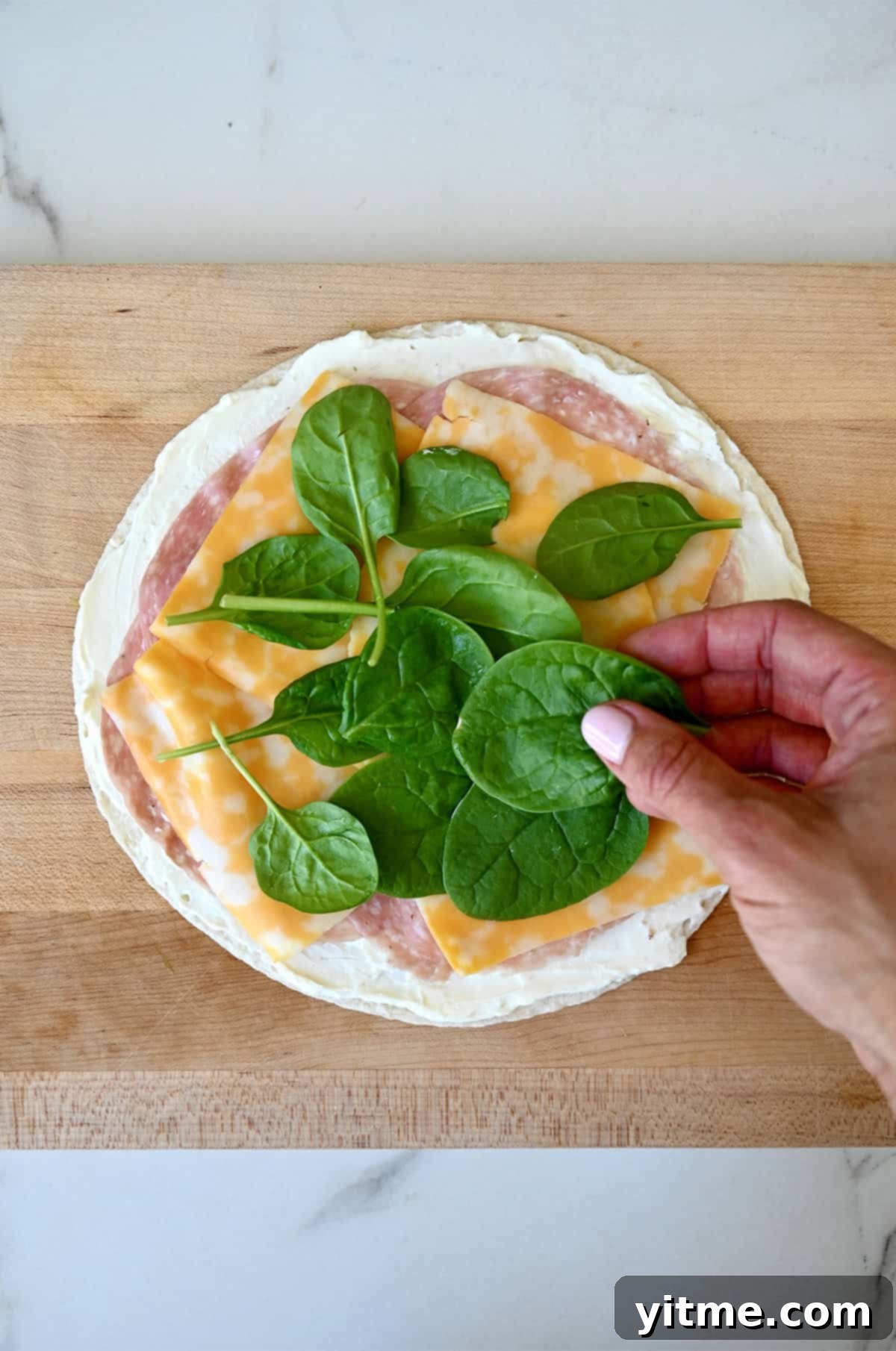 Swirl Sandwiches 5 Layering salami, Colby Jack cheese, and spinach on a tortilla with cream cheese.