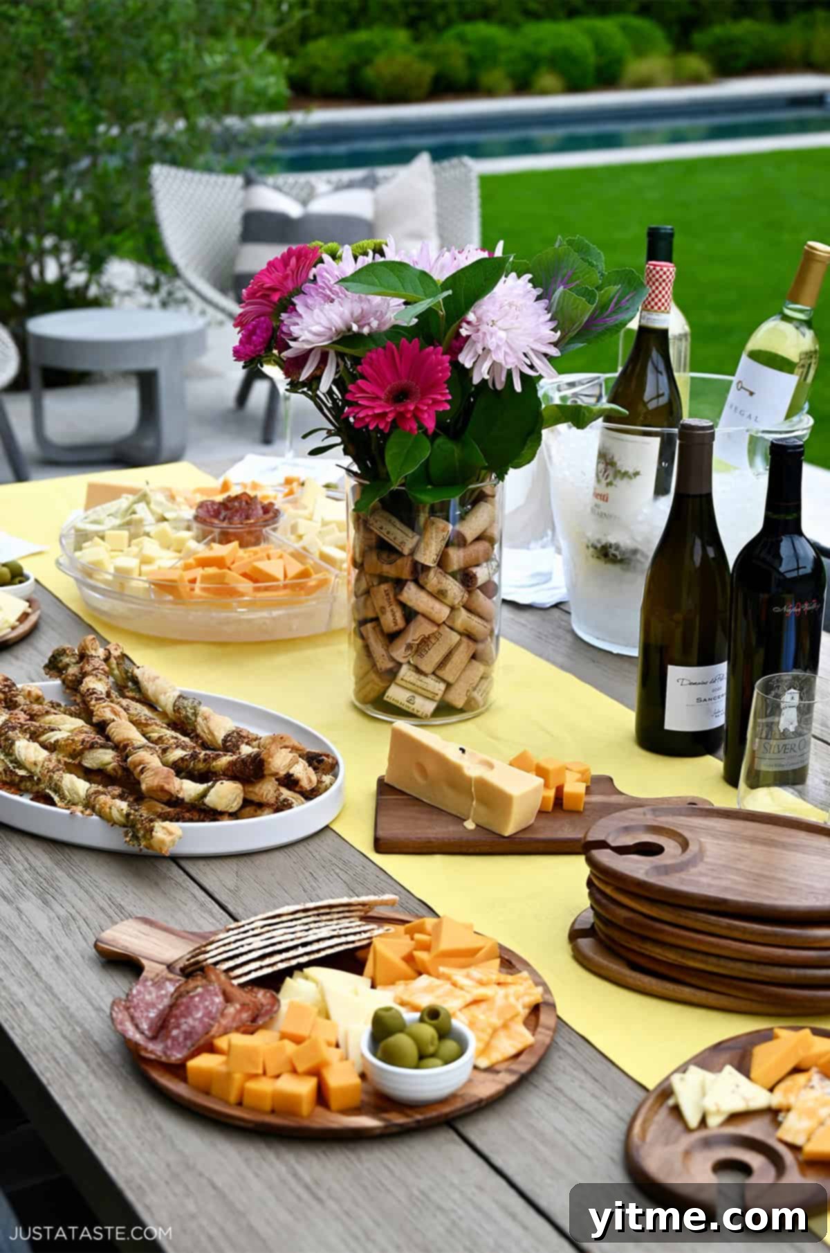 An outdoor table set with wine and cheese for hosting a small party with friends and family, showcasing a beautiful, inviting spread.
